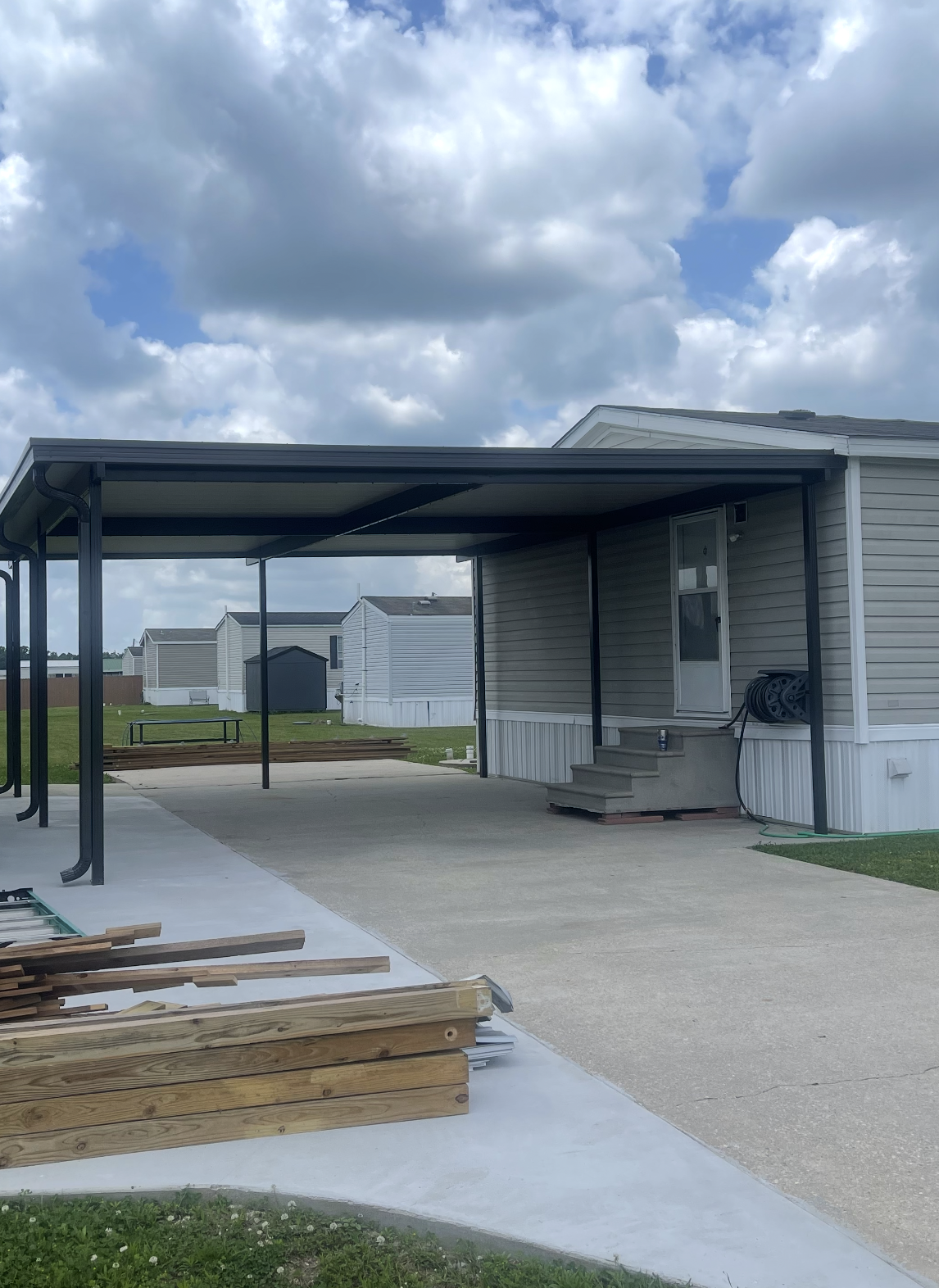 A mobile home with a carport in front of it.