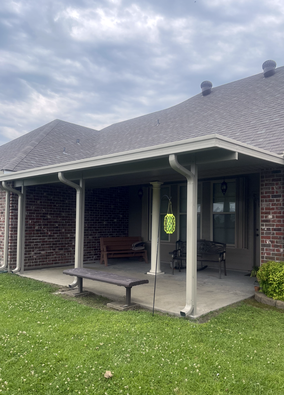 A house with a porch and a bench in front of it.