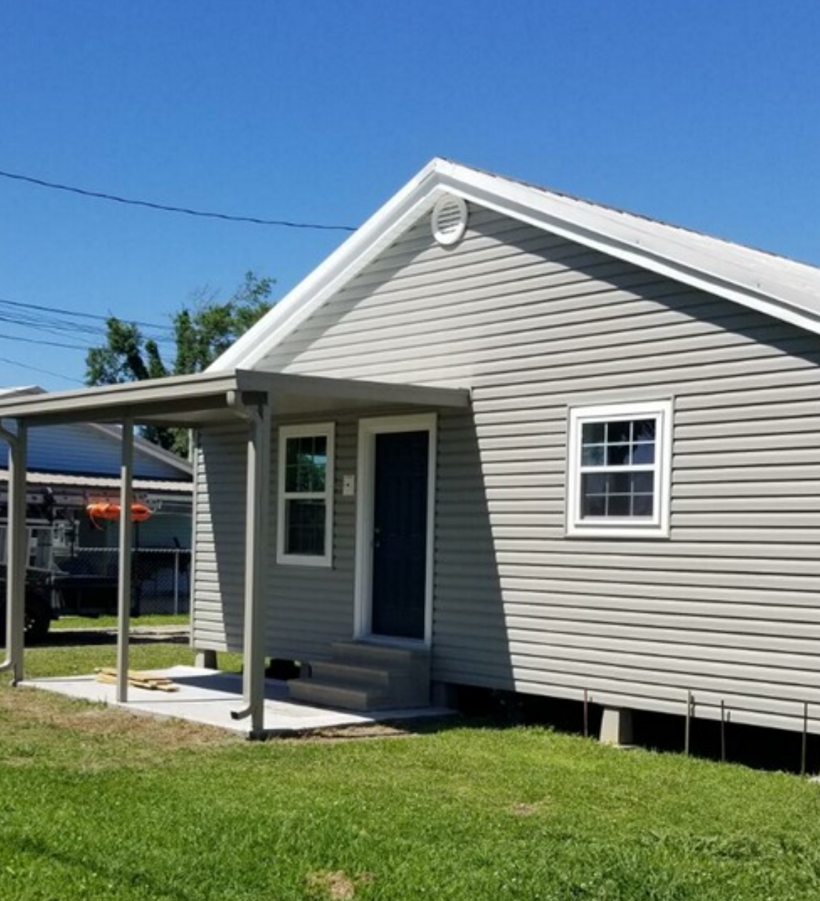 A small house with a porch and a blue door.