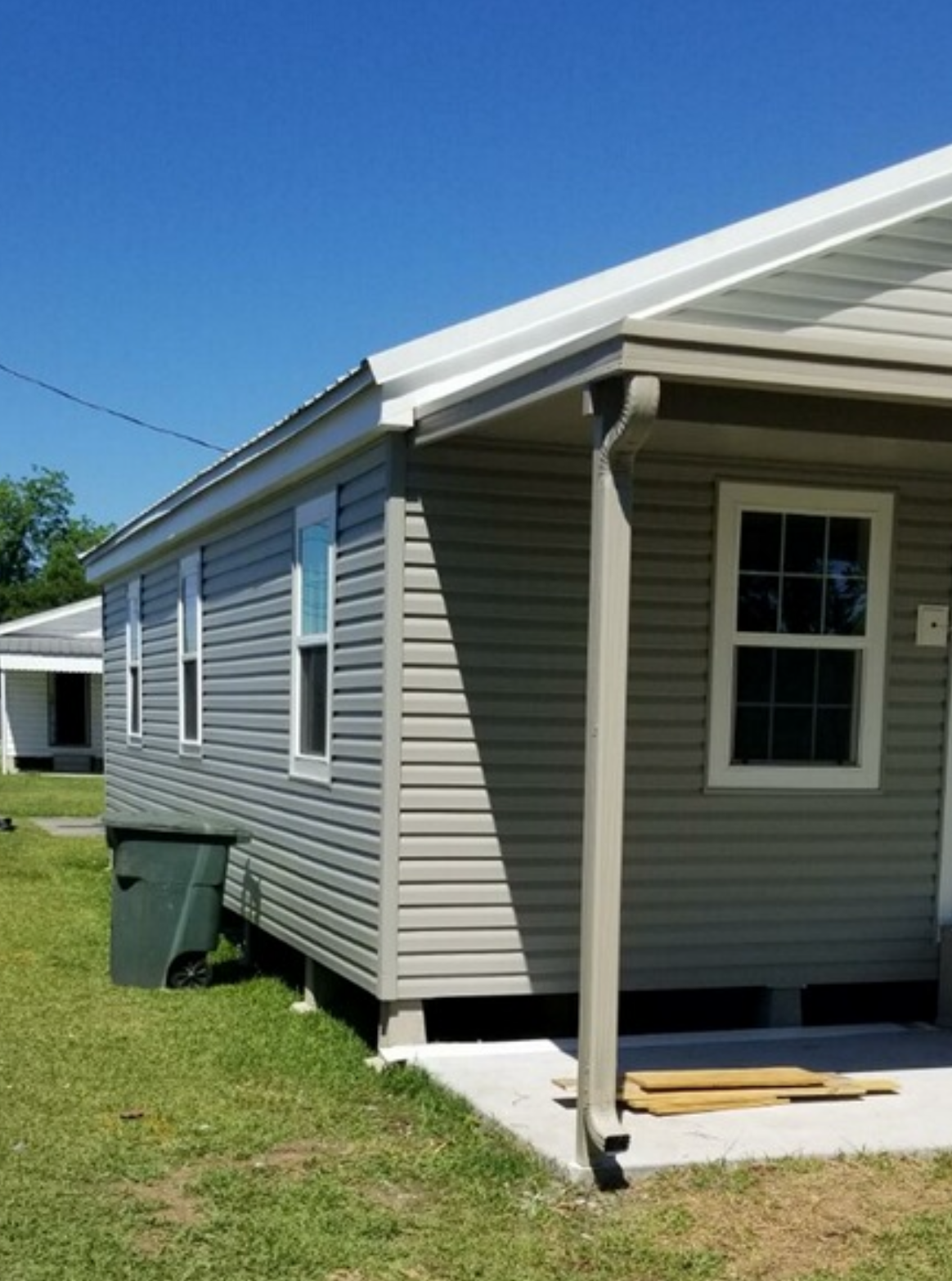 A small house with a porch and a blue sky in the background.
