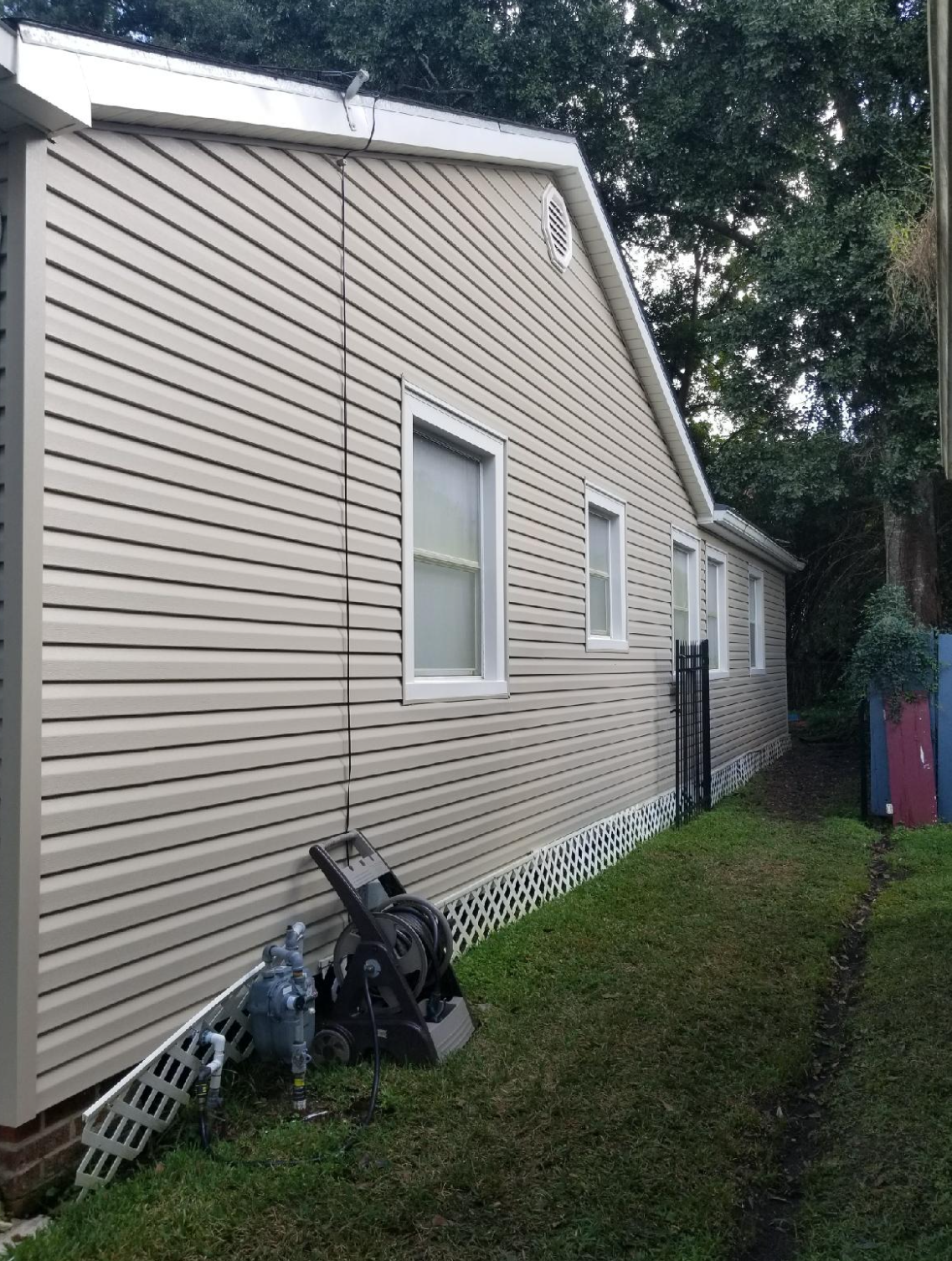 A house with a lot of windows and a vacuum cleaner in the backyard.