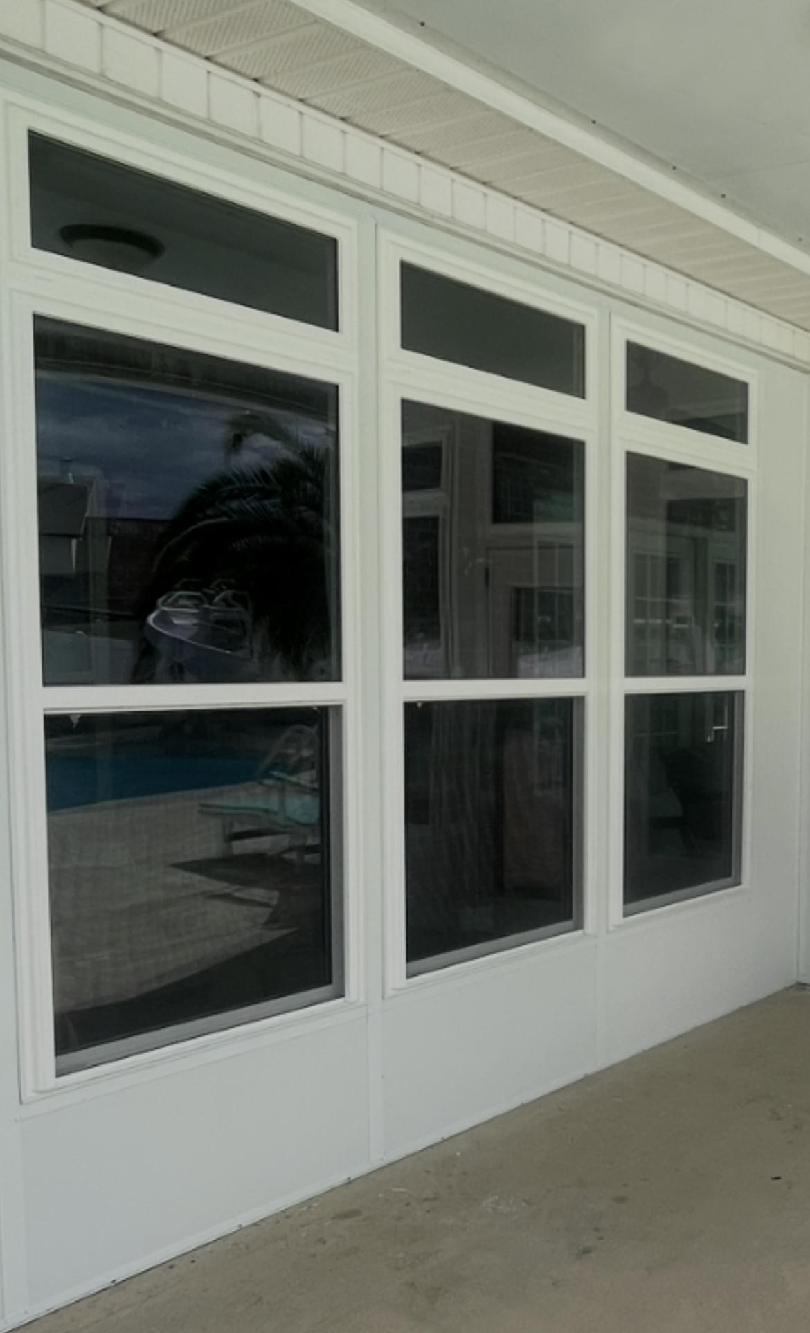 A porch with a rocking chair and a brick wall.