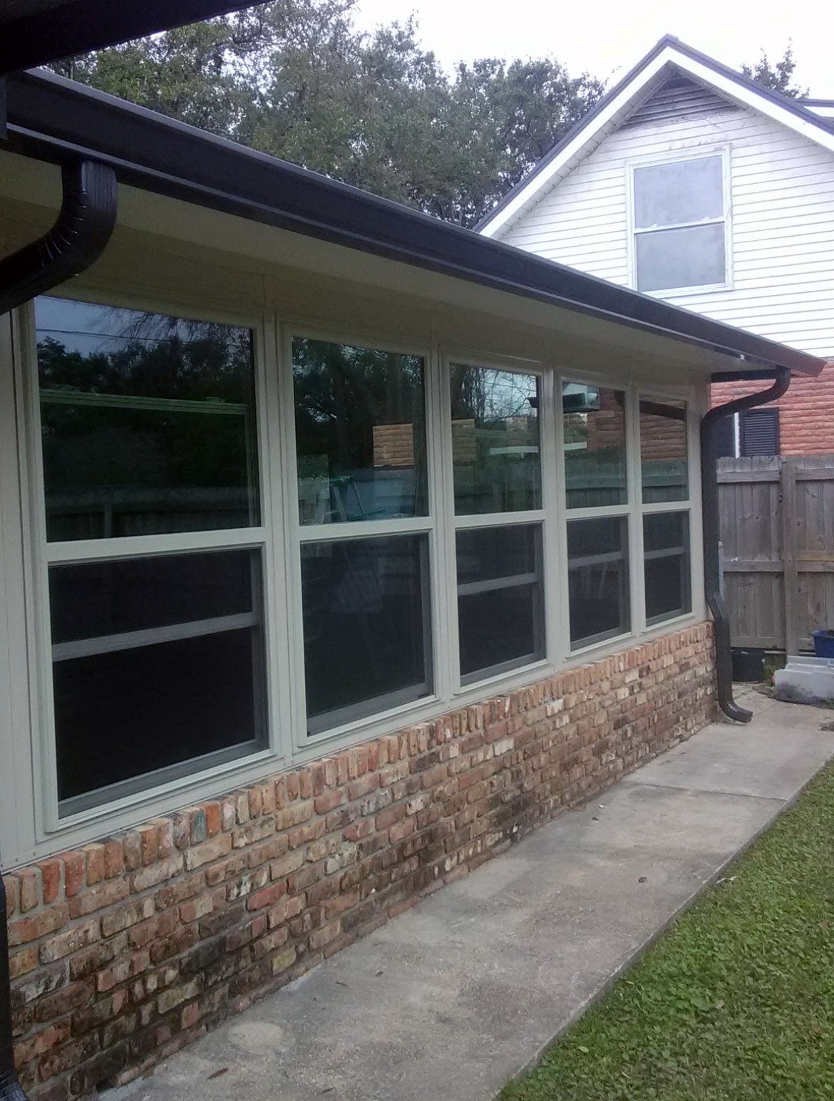 A house with a lot of windows and a lawn in front of it.
