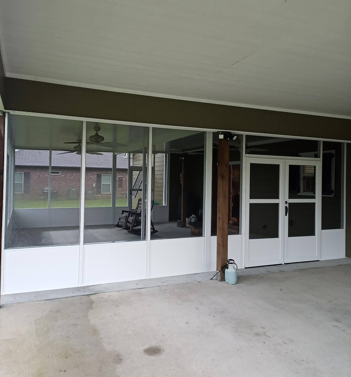 A screened in porch with a lot of windows and doors.