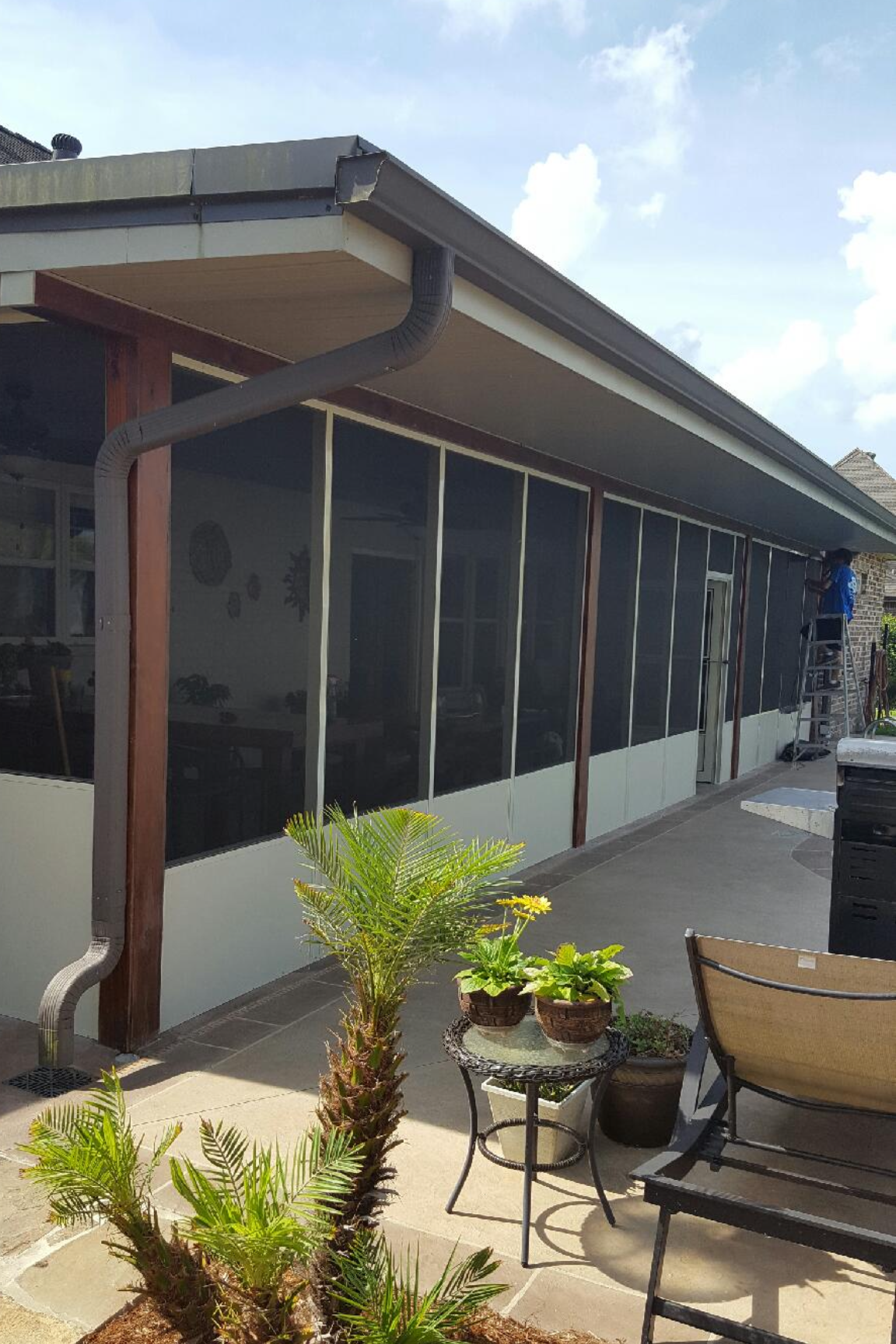 A house with a screened in porch and a patio area.