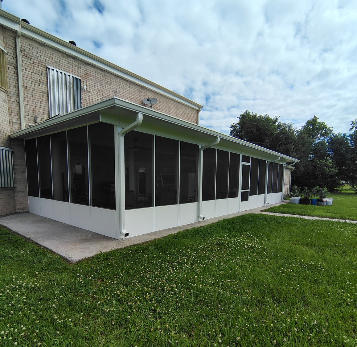 There is a screened in porch on the side of a house.