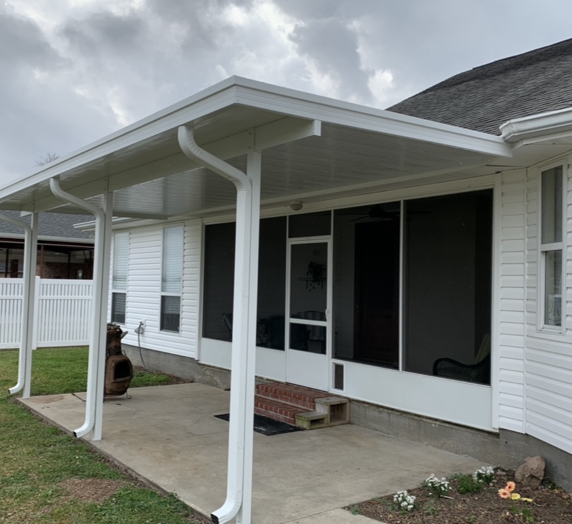 A white house with a screened in porch and a white roof.