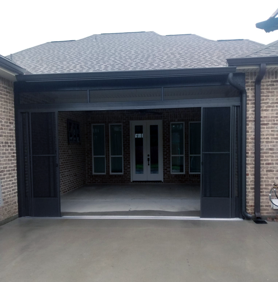 A brick house with a garage door that is open.