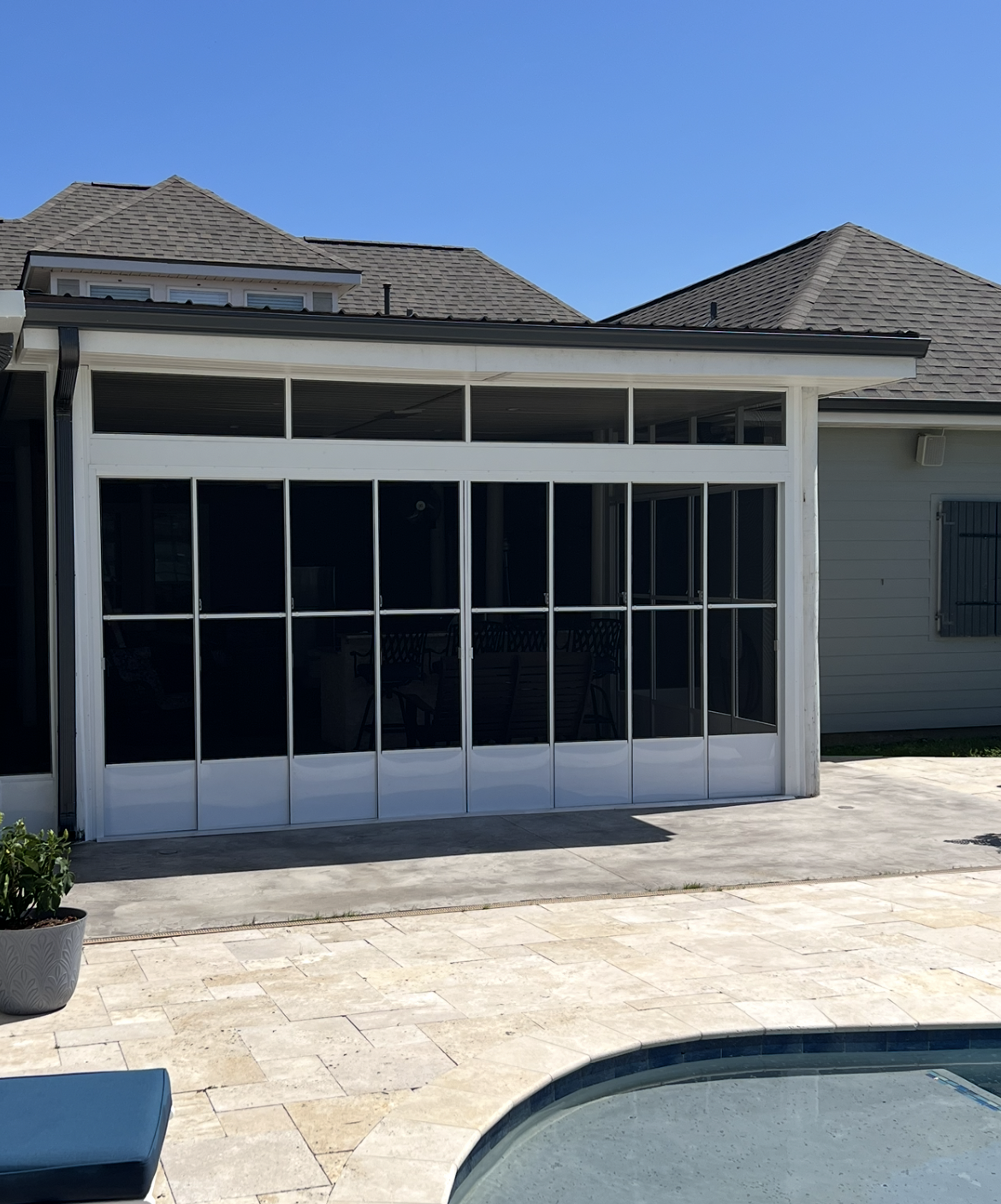A house with a swimming pool in front of it.