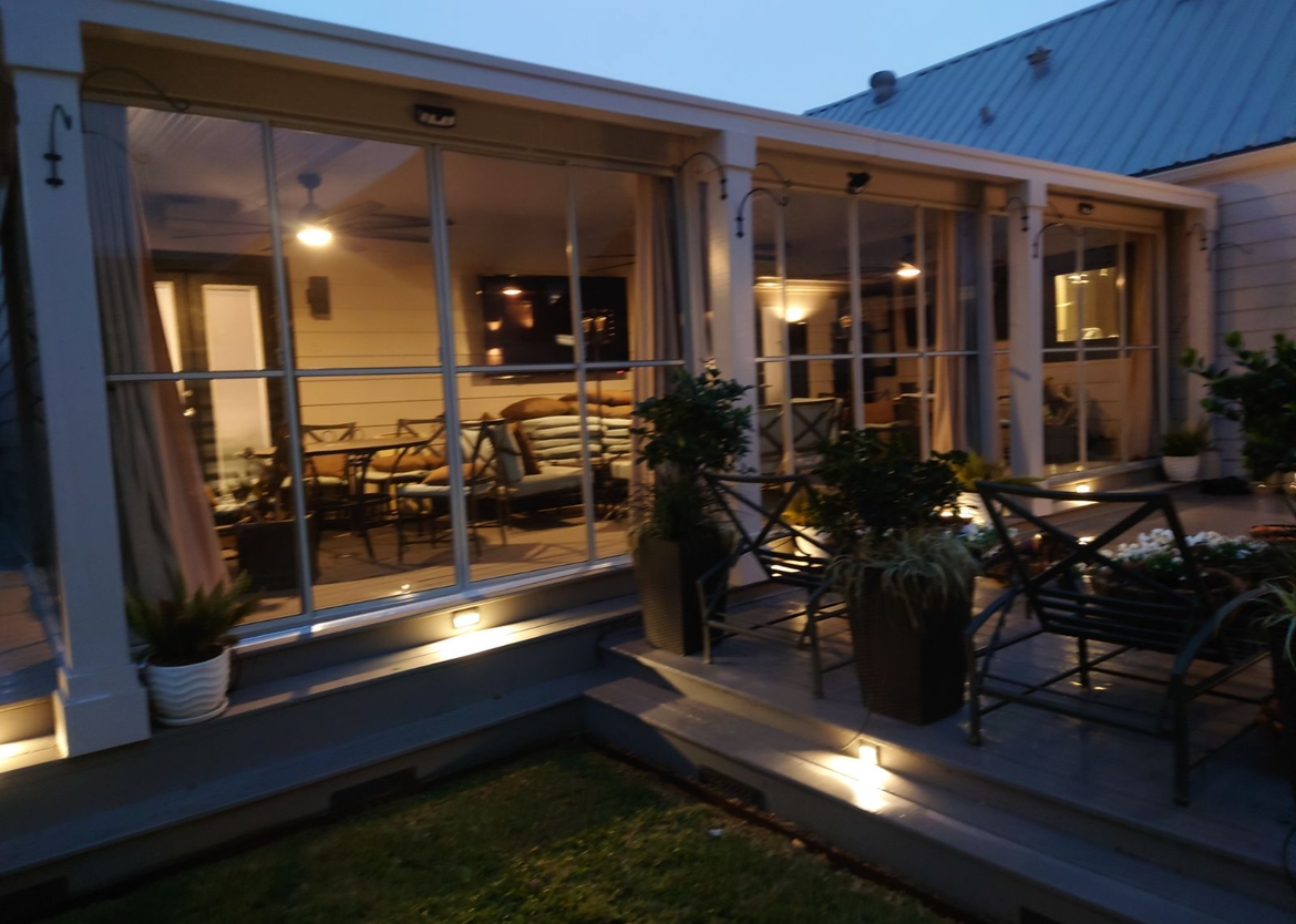 A building with a lot of windows and plants in front of it.