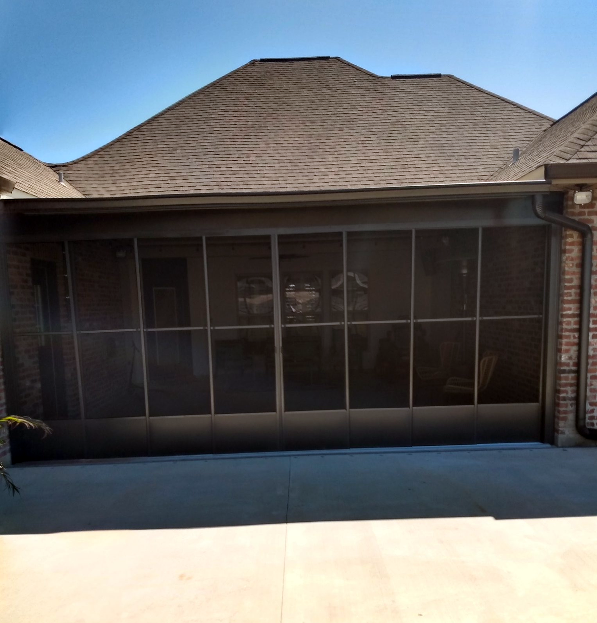 A brick house with a screened in garage door.