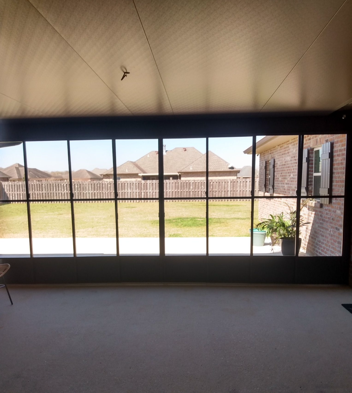 A large window with a view of a brick house.