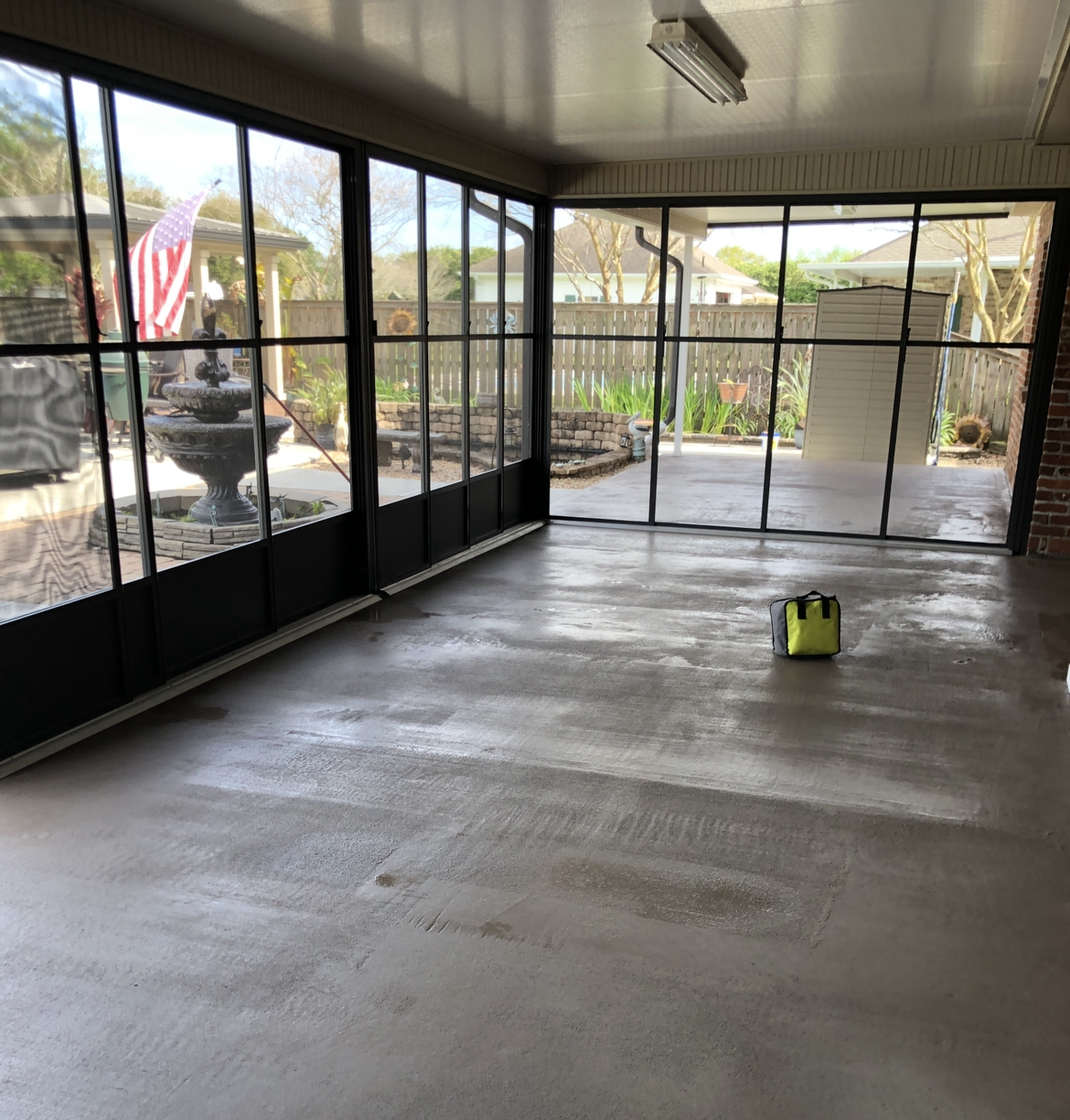 A room with a lot of windows and a yellow bag on the floor.