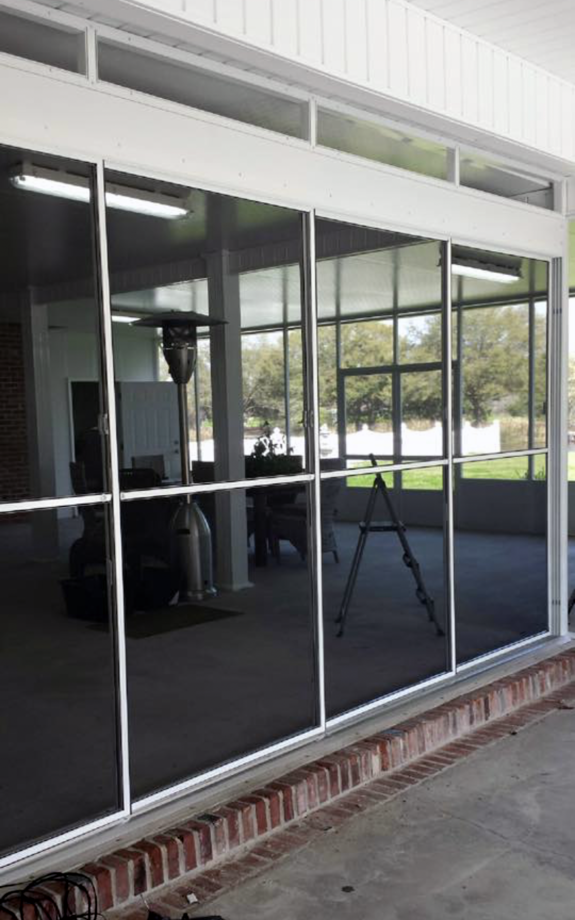 A room with a lot of windows and a ladder in the background.