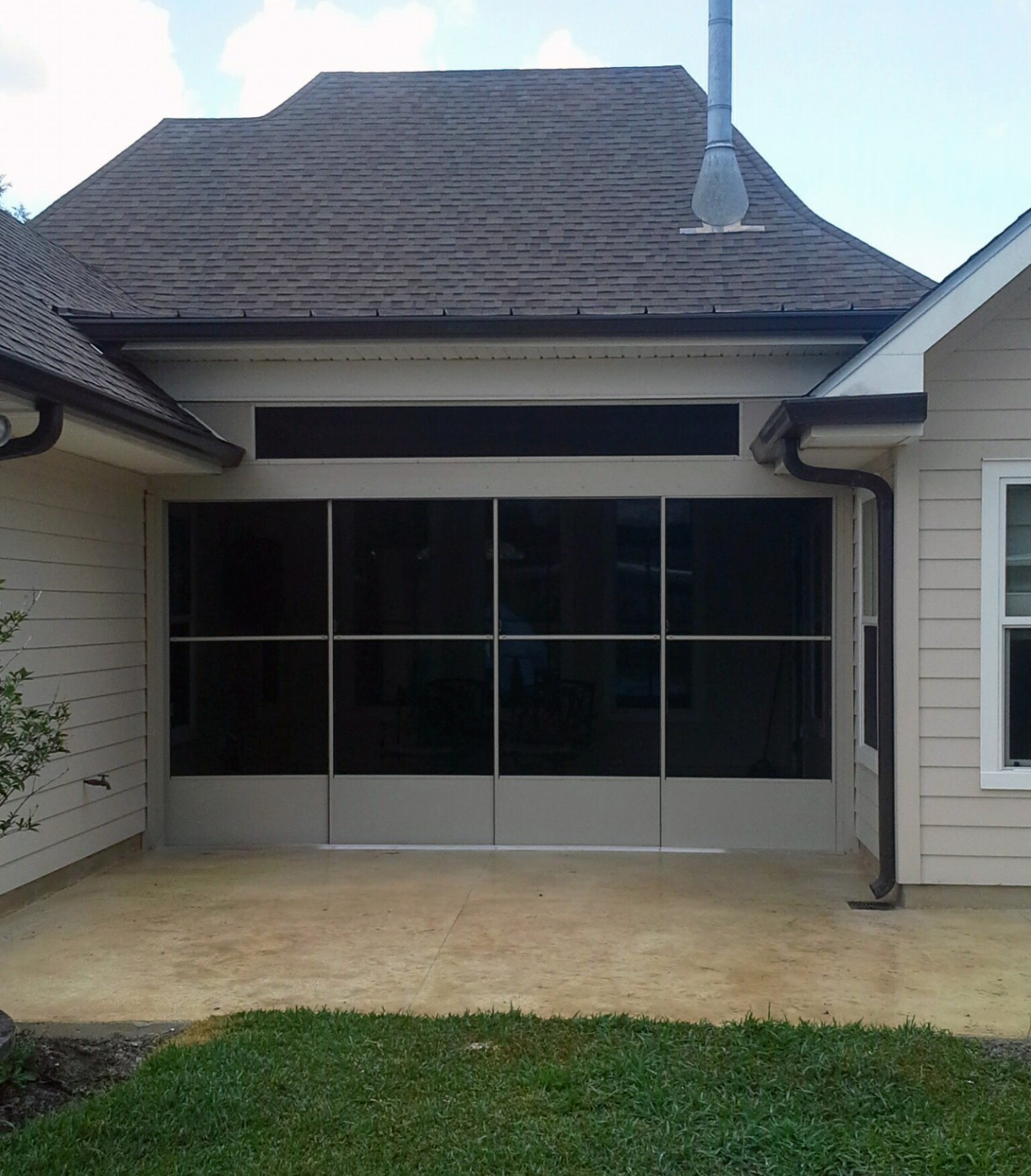 The back of a house with a screened in porch.