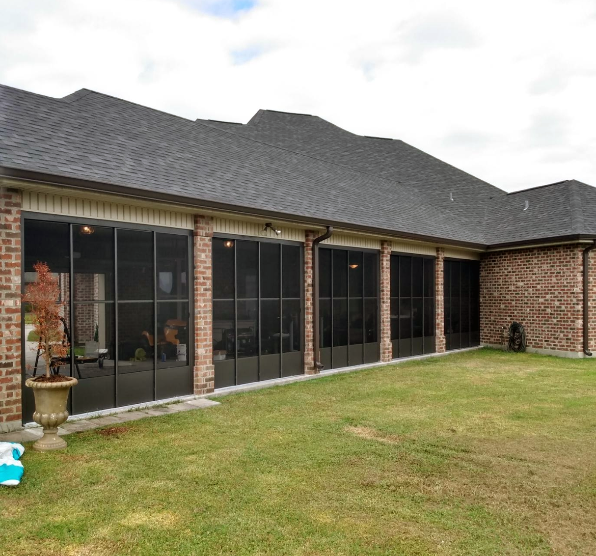 A brick house with a lot of screened in windows.