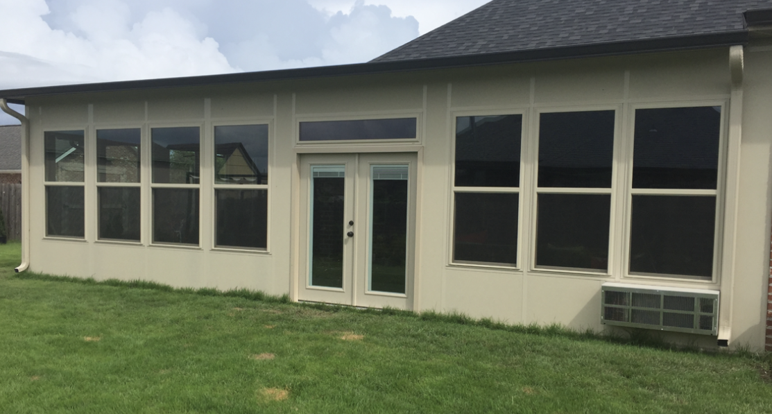 A house with a screened in porch and a lot of windows.
