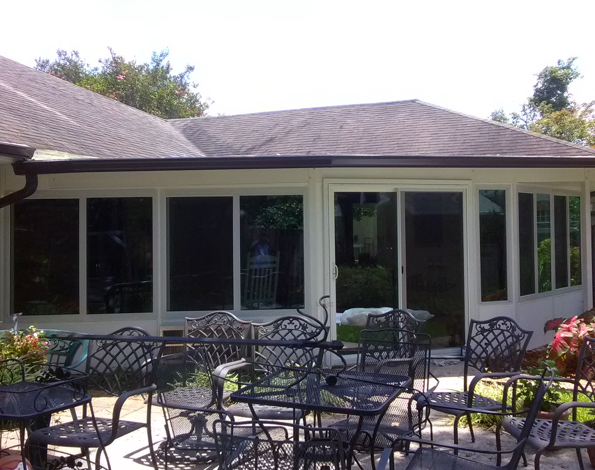 A patio with tables and chairs in front of a house.