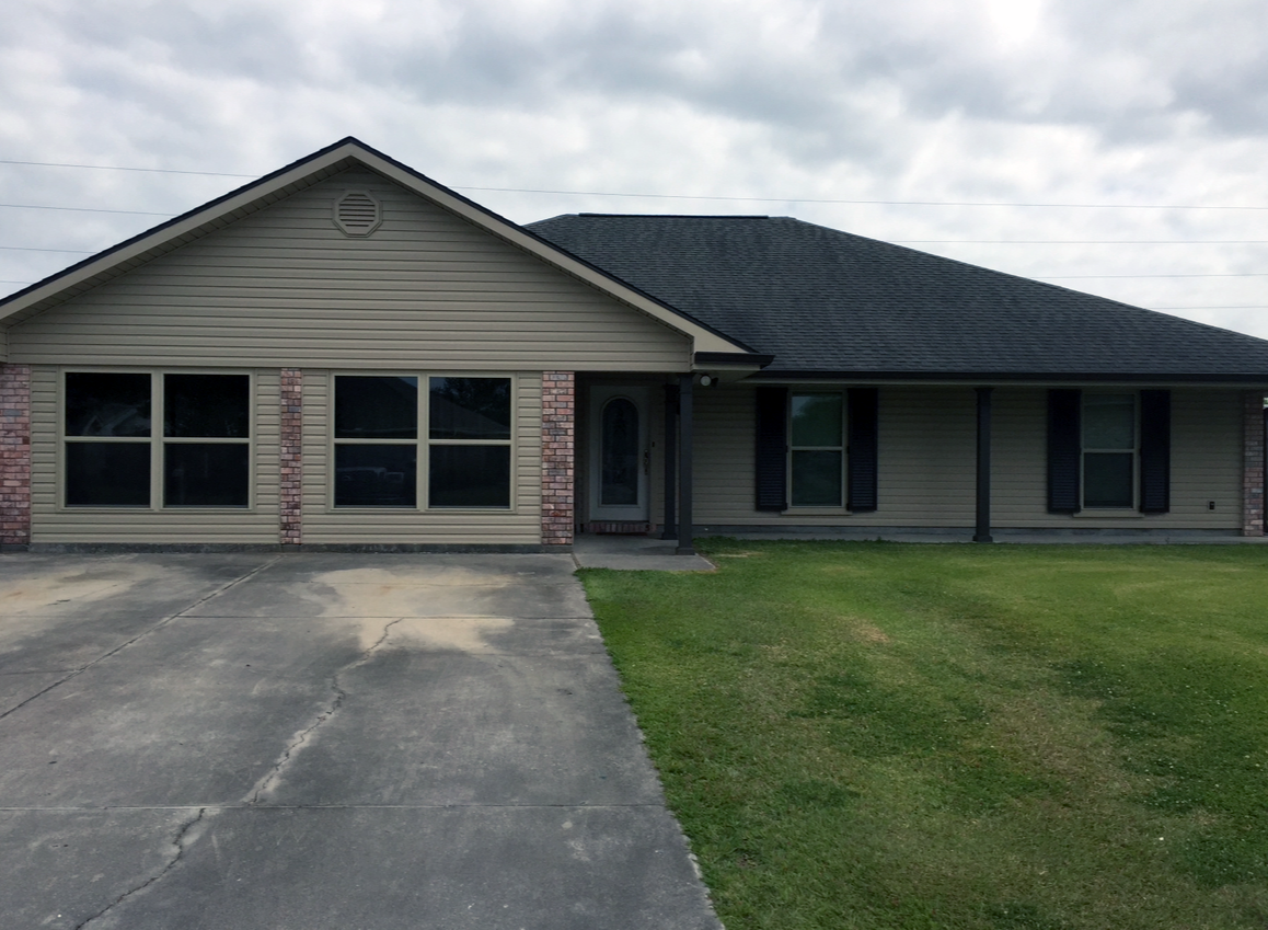 A large house with a large driveway in front of it.