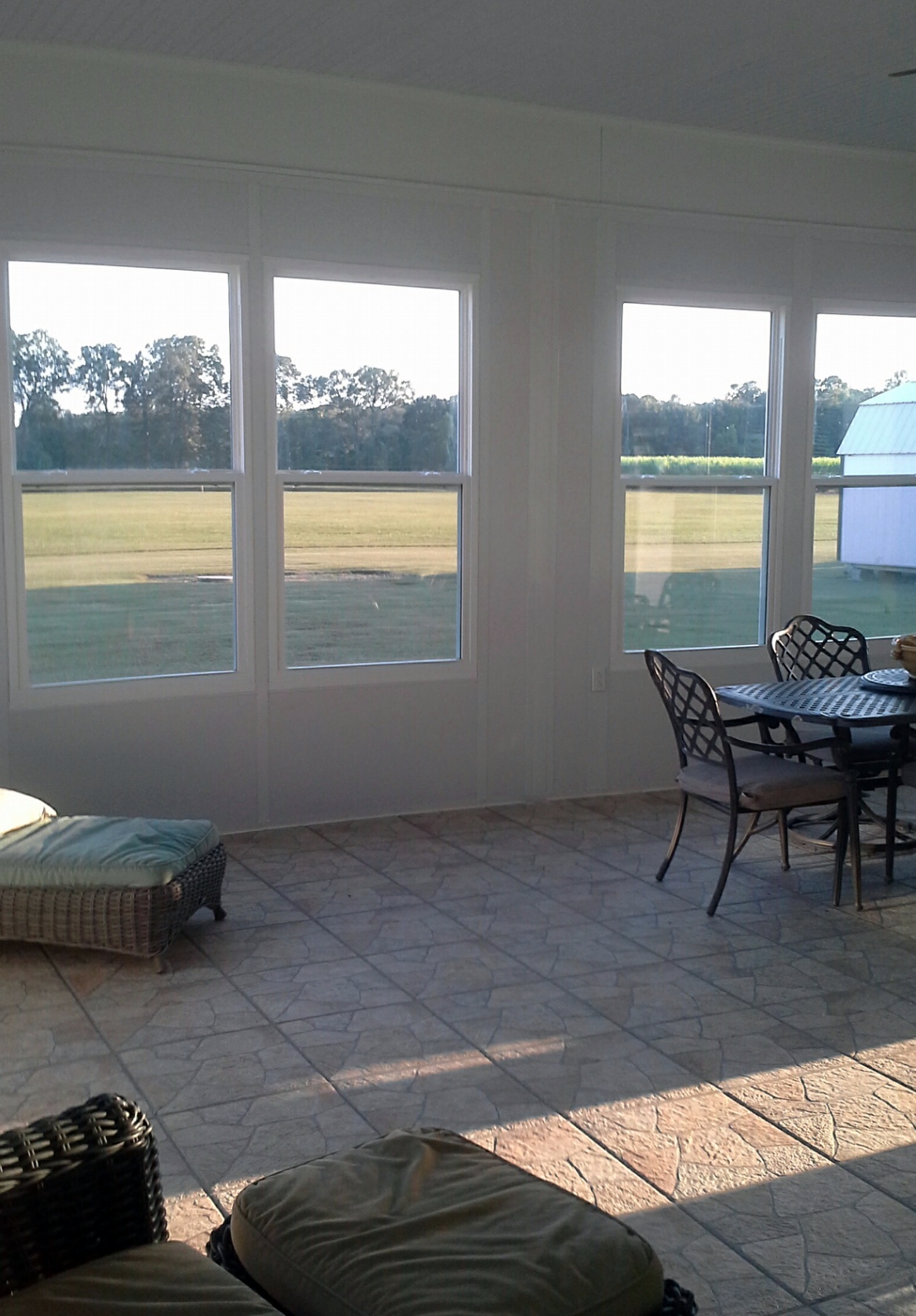 A living room with a table and chairs and a large window.