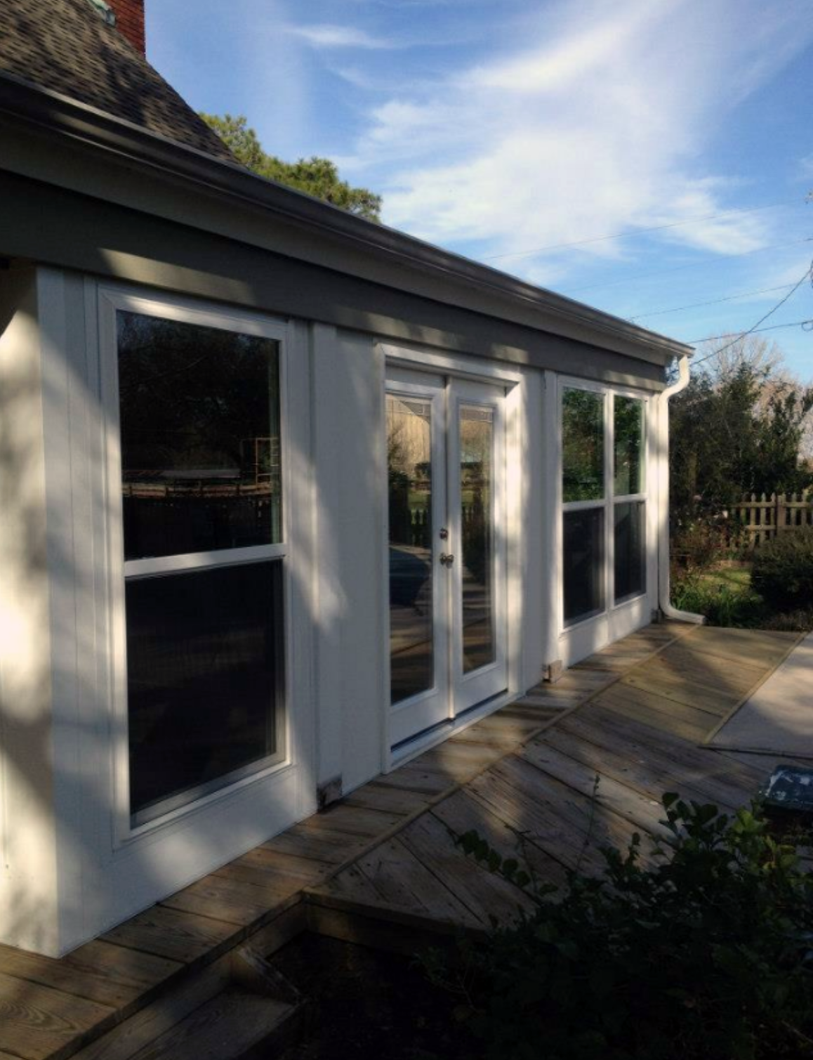 A house with a lot of windows and sliding glass doors.