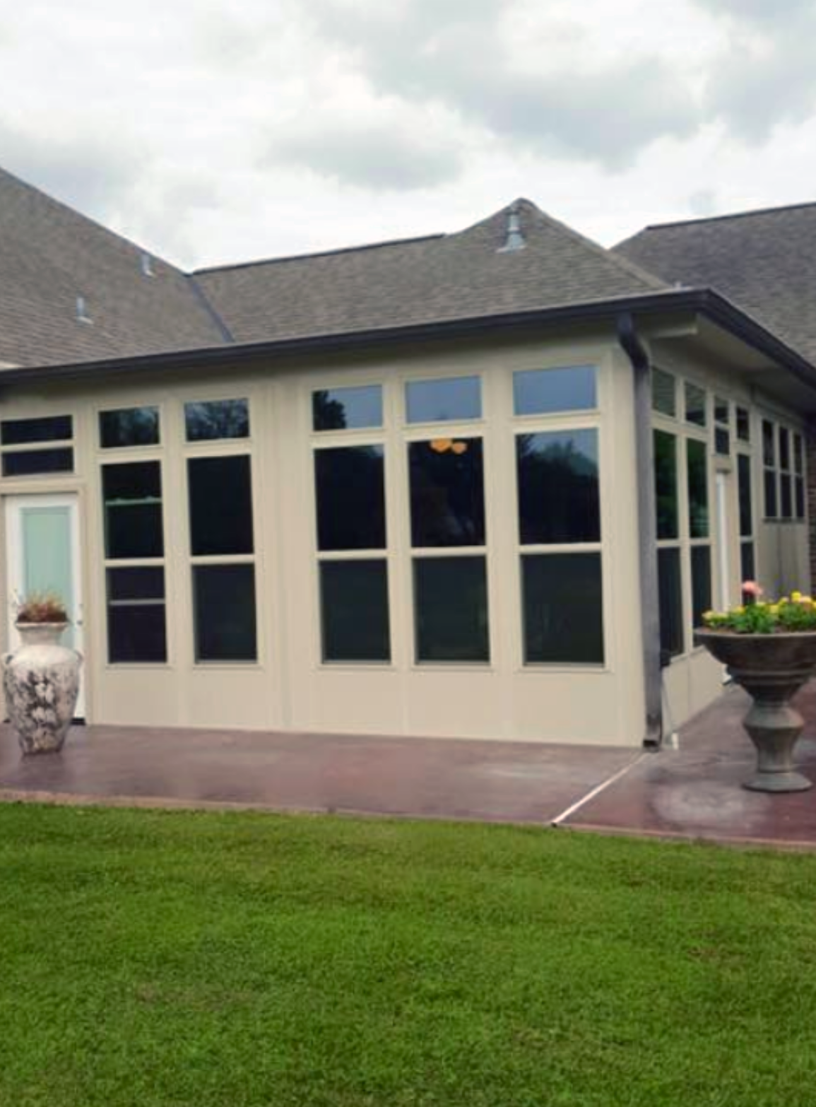 A house with a lot of windows and a lawn in front of it.