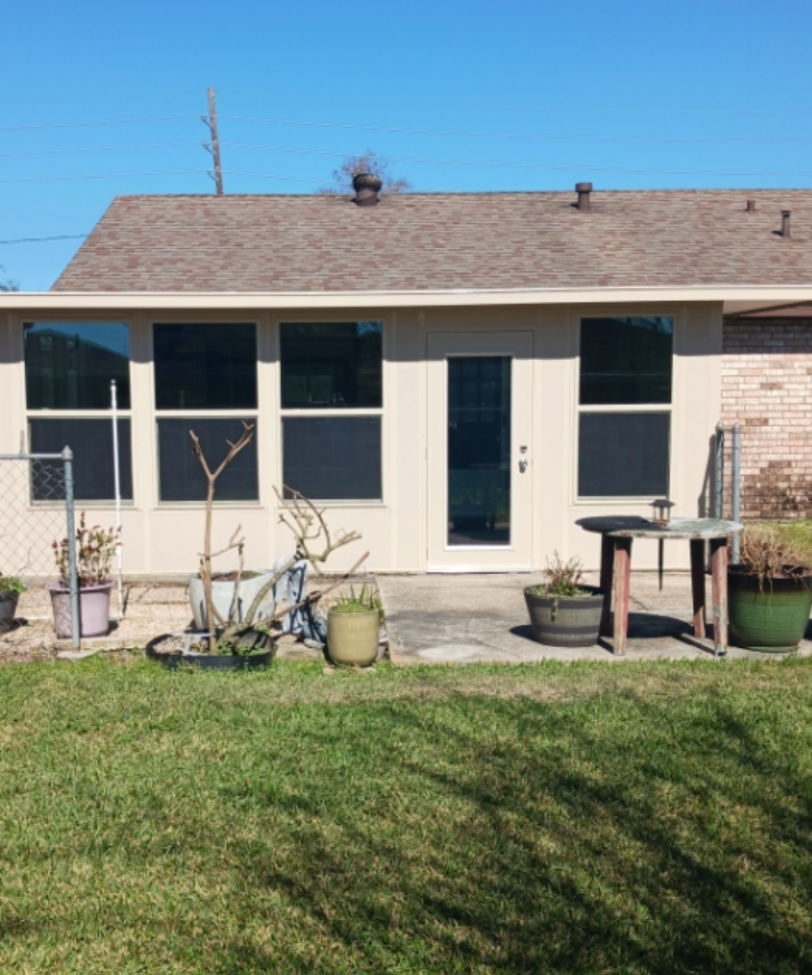 A house with a lot of potted plants in front of it.