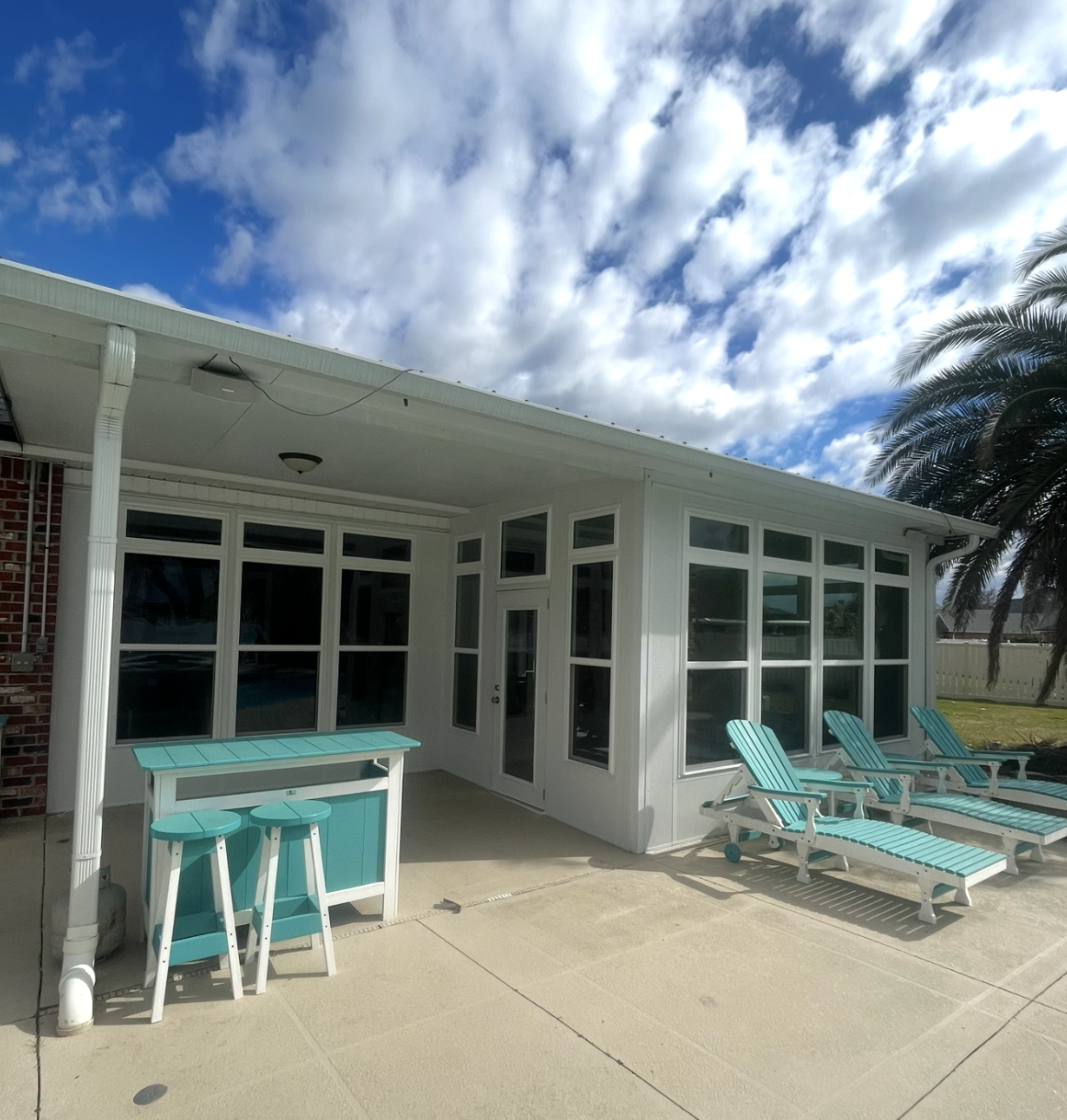 A white house with blue chairs and a table.