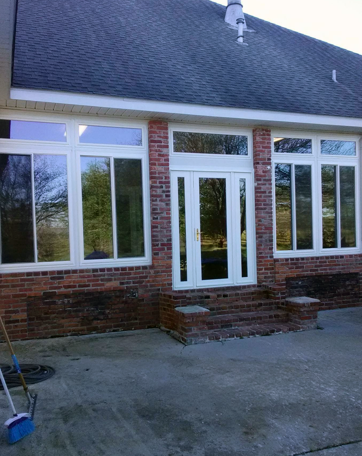 A brick house with white windows and a black roof.