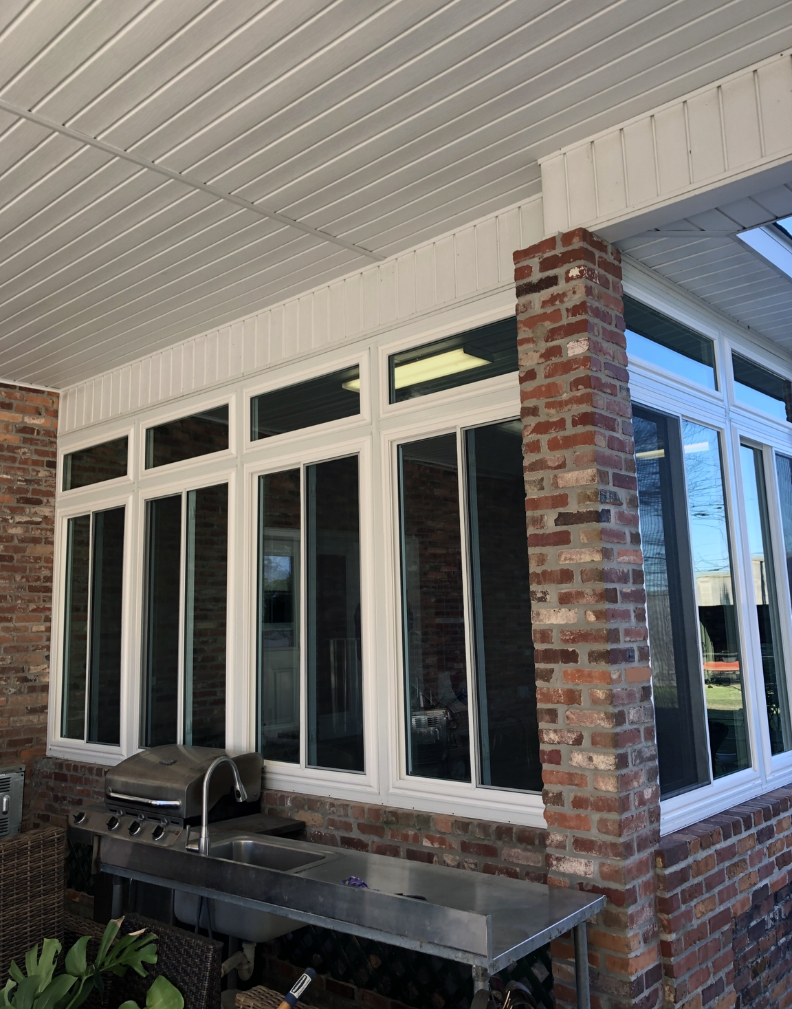 A brick building with a grill and a table in front of it.