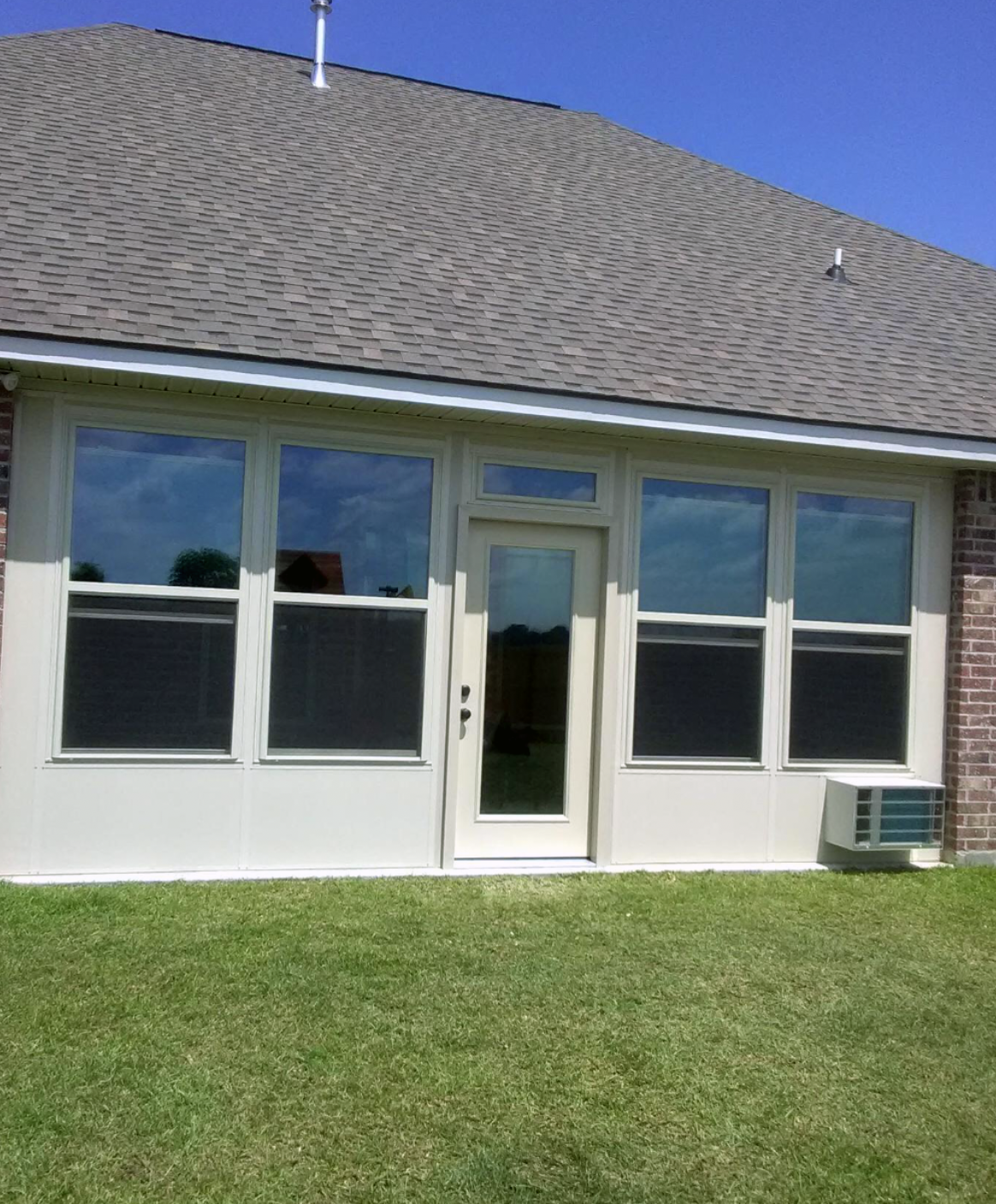 A house with a lot of windows and a sliding glass door.