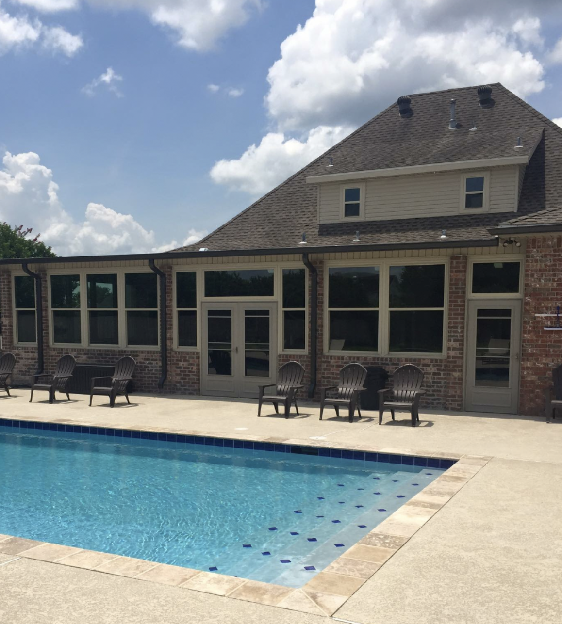 A large house with a swimming pool in front of it.