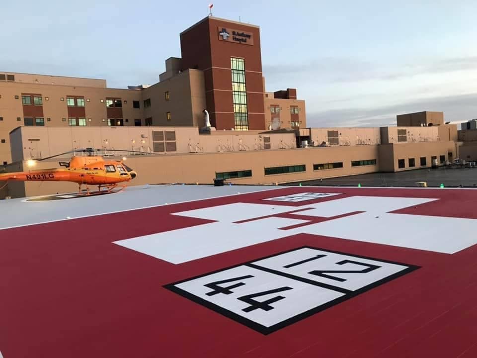 A helicopter is on the roof of a hospital