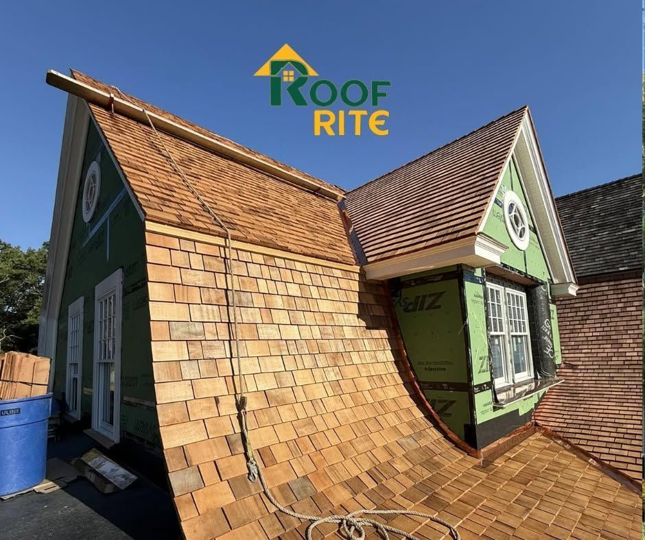 Workers installing a tan shingle roof on a house