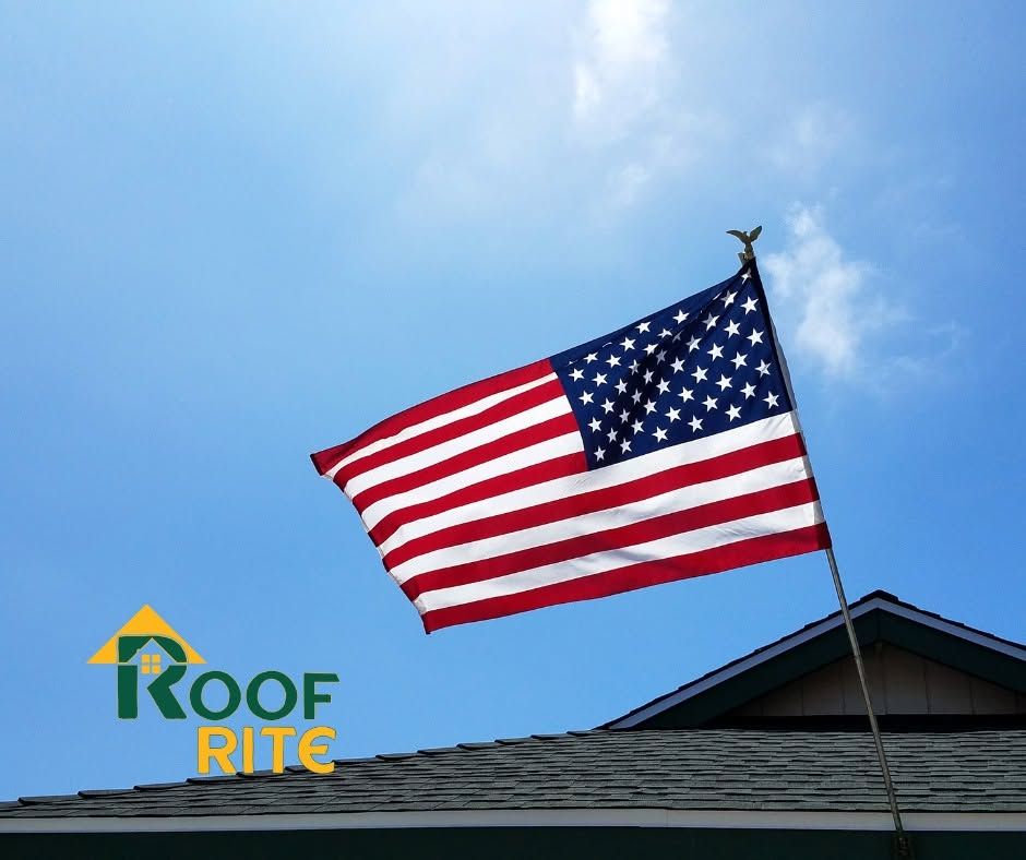 American flag flying above a rooftop against a blue sky