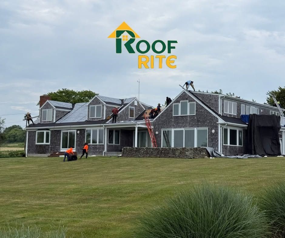 Roof Rite crew repairing a gray roof on a house with ladders and workers on site