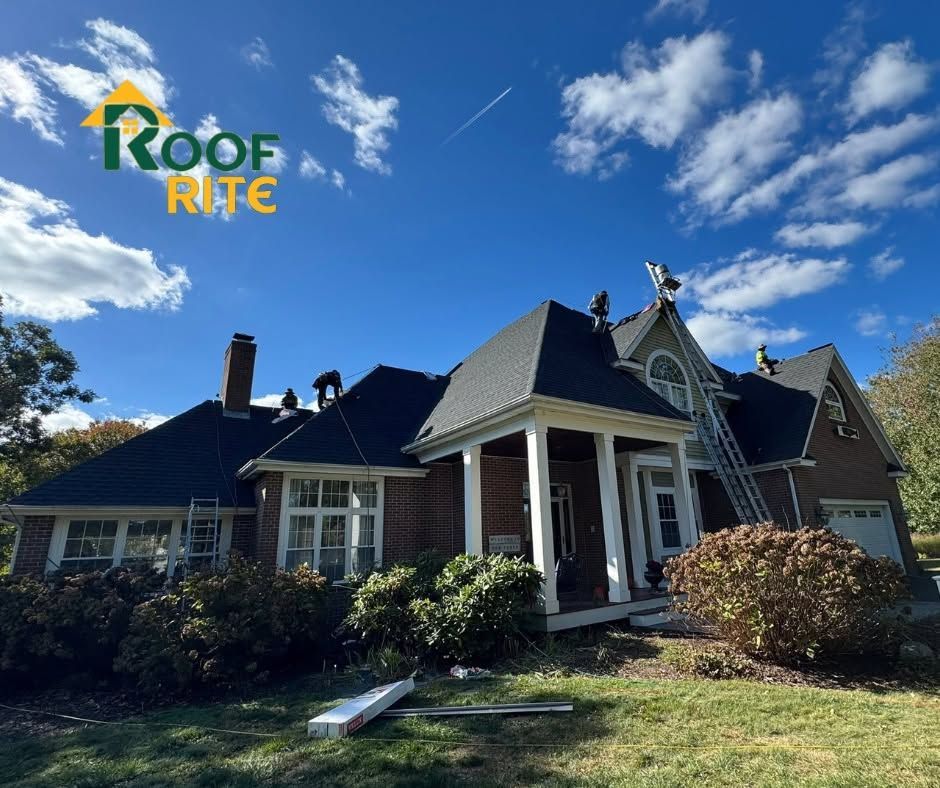 Single-story house with dark roof and white porch under a blue sky