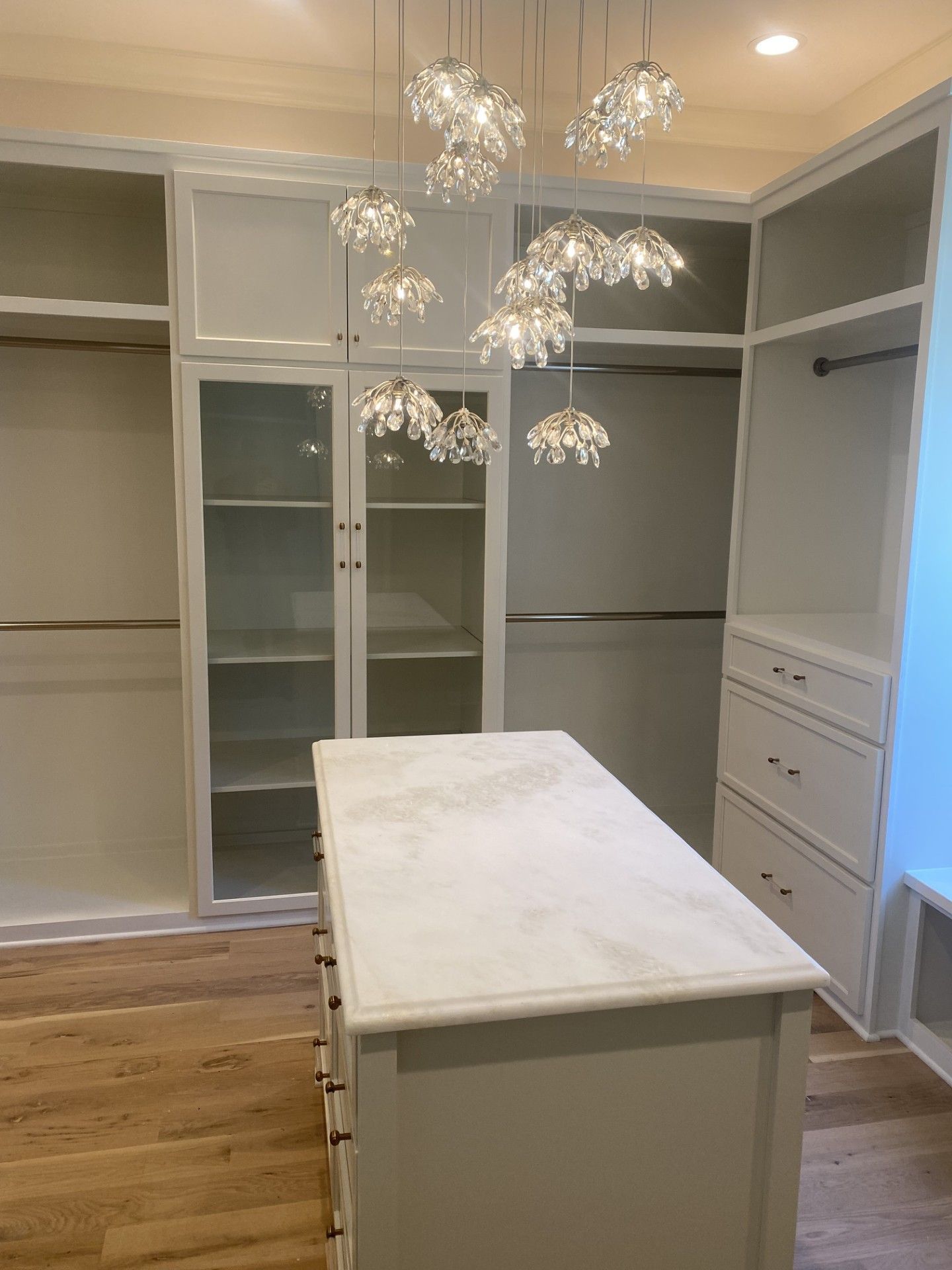 A walk in closet with a large island in the middle.
