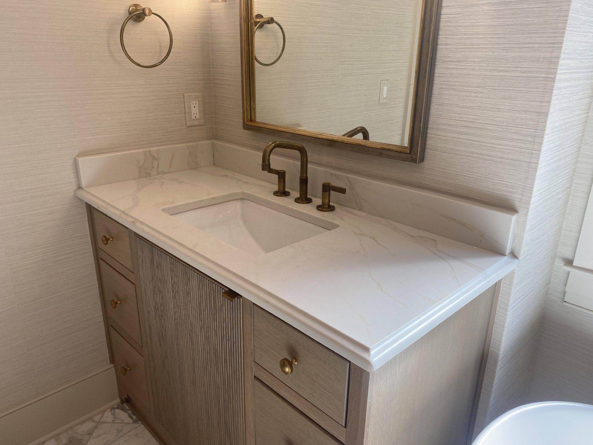 A bathroom with a sink , mirror and bathtub.
