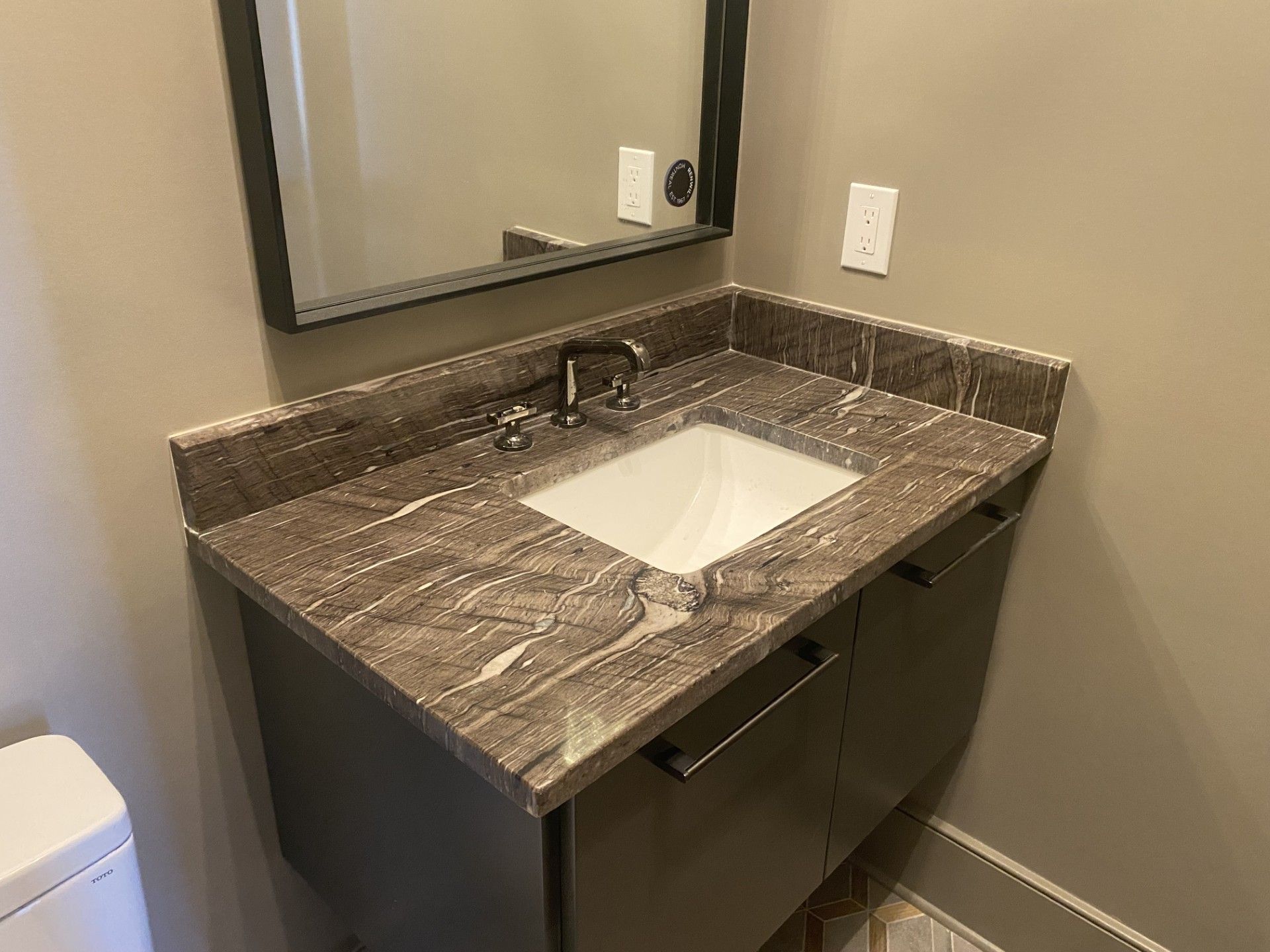 A bathroom with a sink , mirror and toilet.