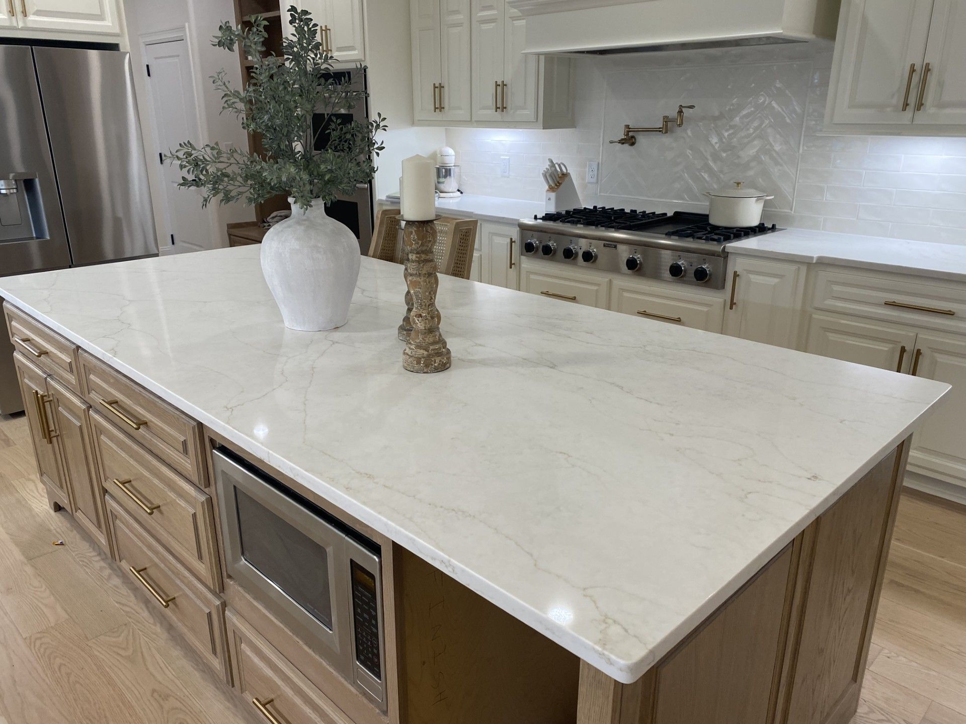 A kitchen with a large island and a vase on top of it.