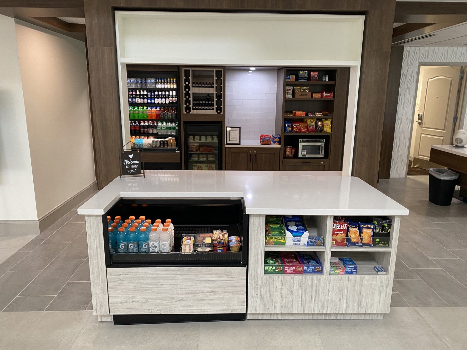 A hotel lobby with a snack bar and a refrigerator.