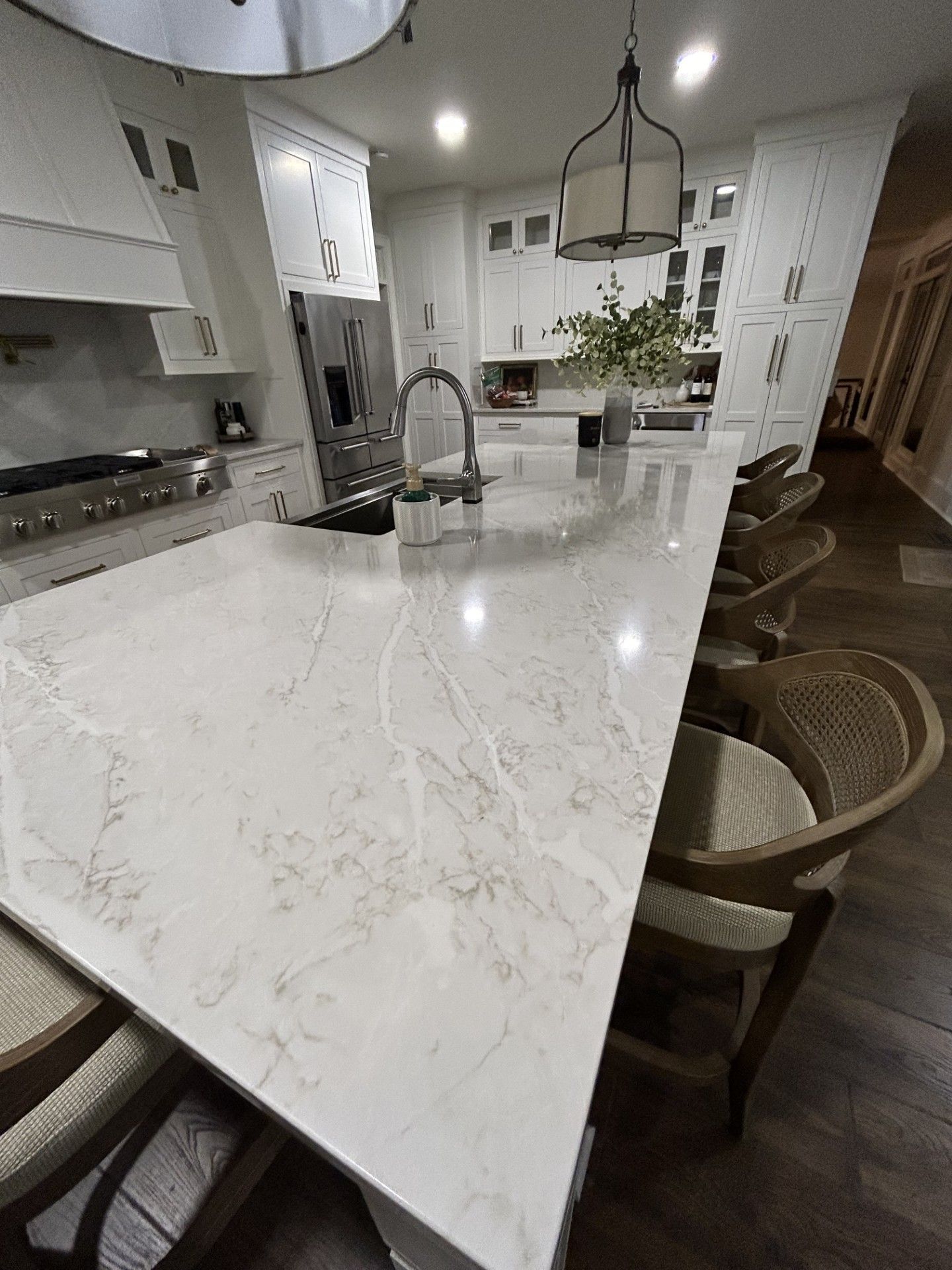 A kitchen with a large white counter top and a sink.