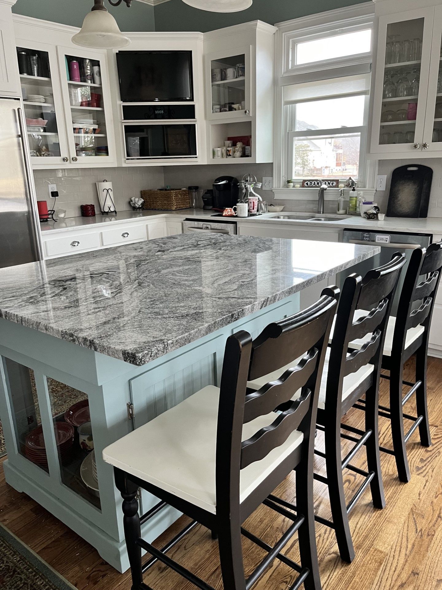 A kitchen with a large island and chairs in it.