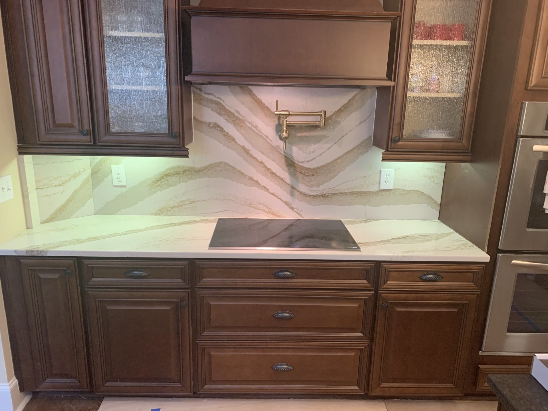 A kitchen with wooden cabinets and a stove top oven.