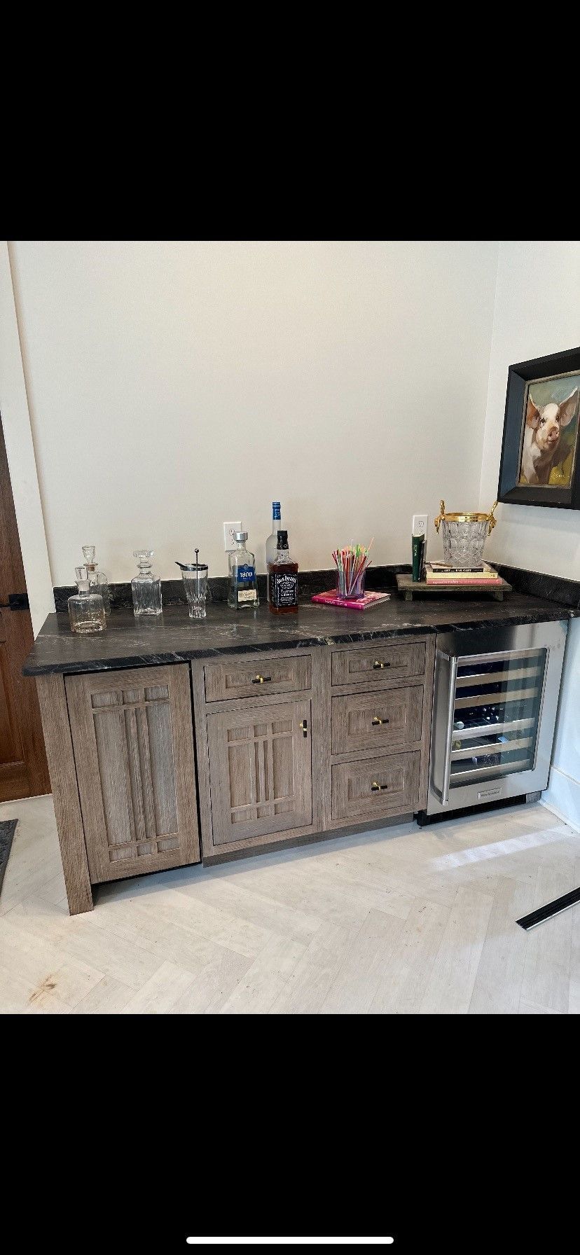 A kitchen with a bar and a refrigerator.