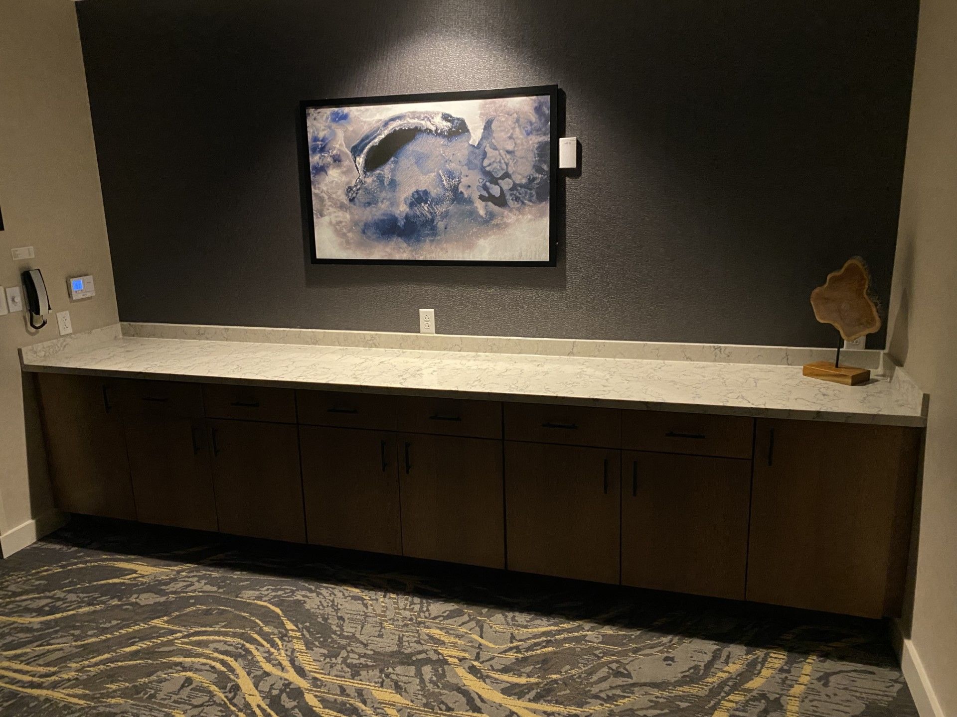A long counter with a picture on the wall above it.