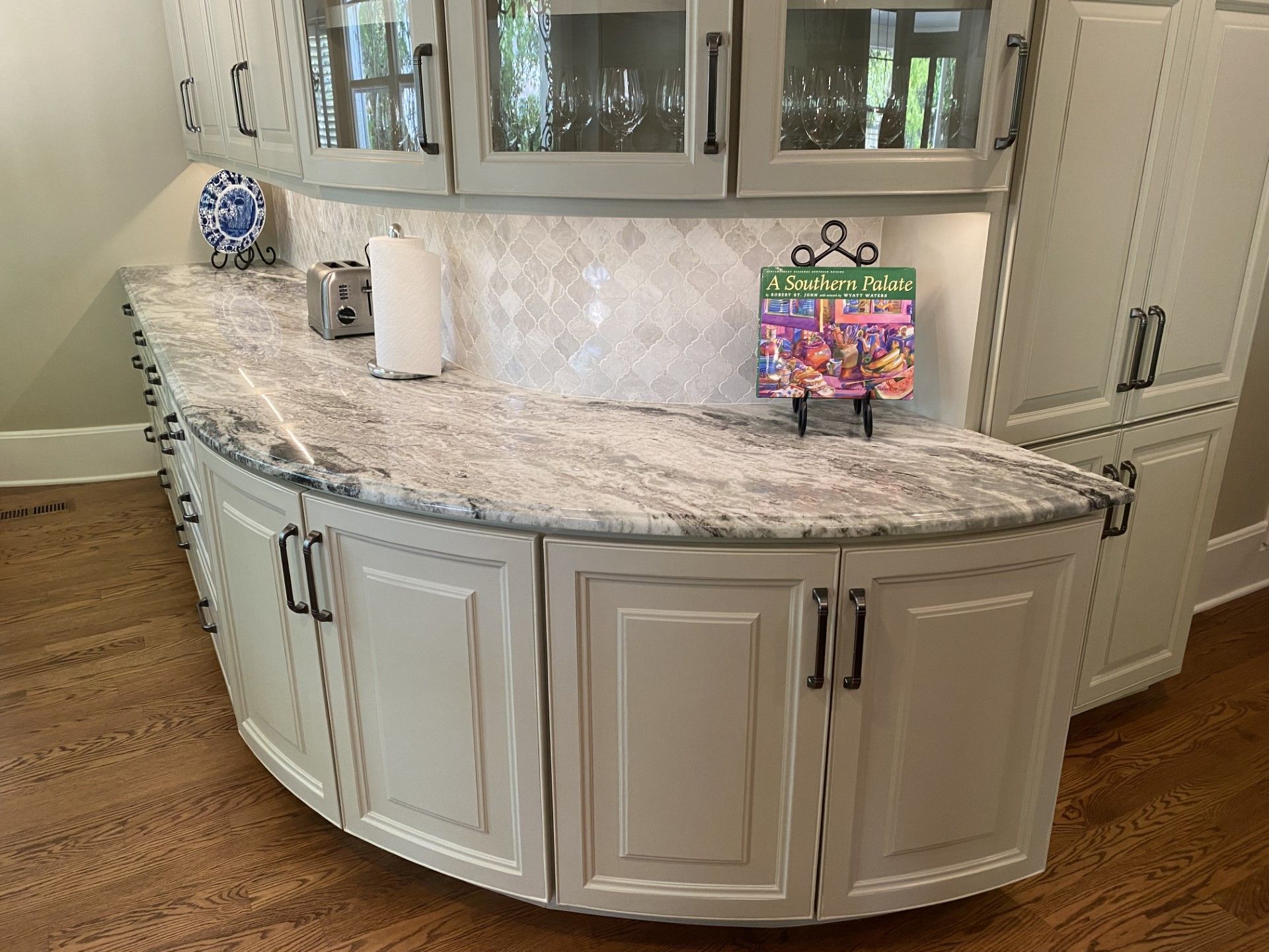 A kitchen with white cabinets and granite counter tops.