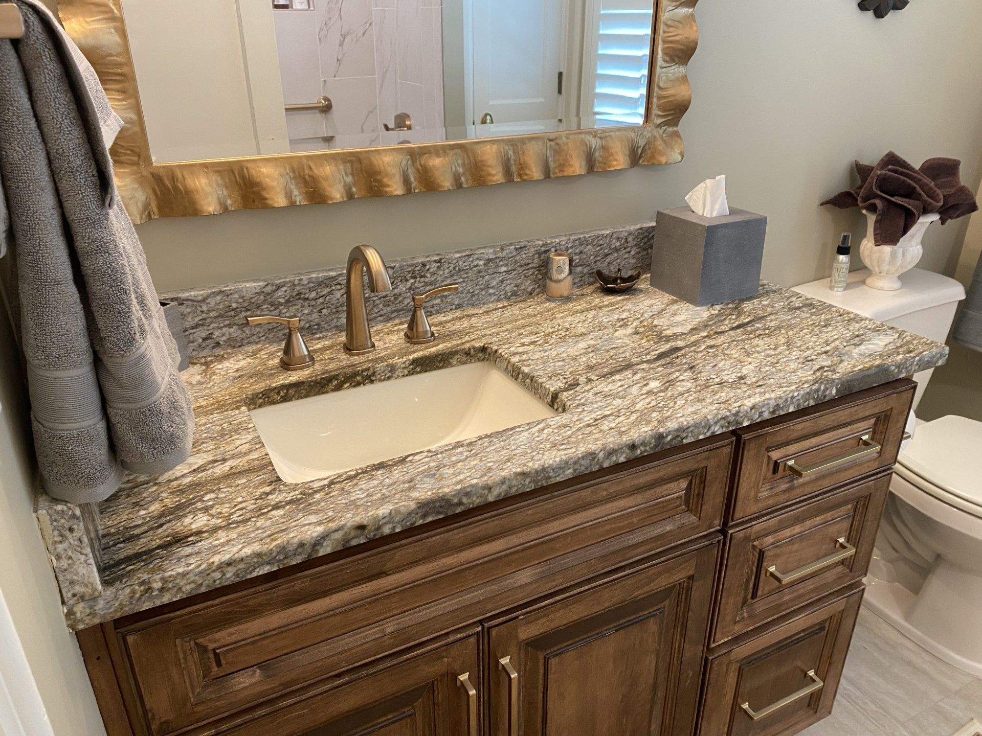 A bathroom with a sink , toilet and mirror.