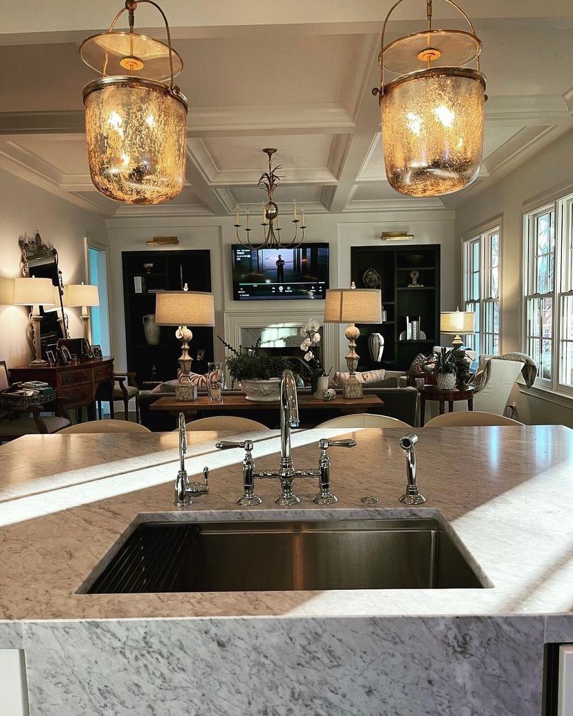 A kitchen with a sink and lamps hanging from the ceiling